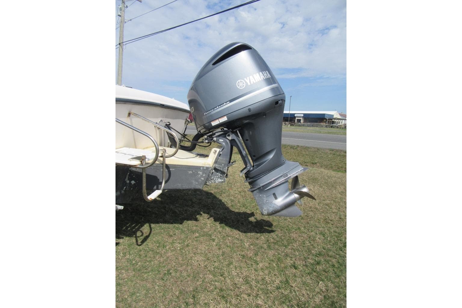 Outboard motor on 2004 Grady-White Seafarer 228 boat, parked on grass.