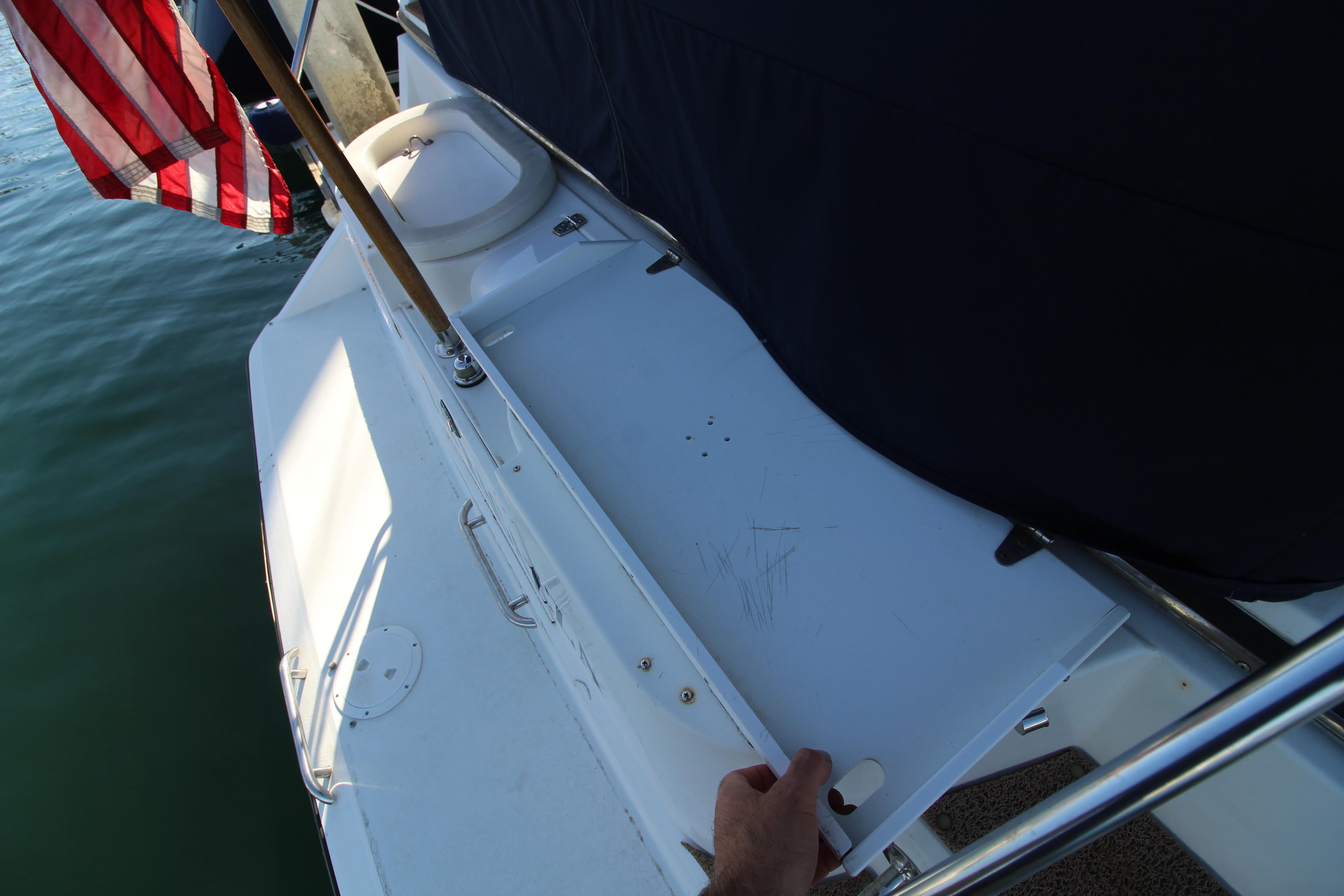 1990 Carver 3467 Santego boat deck with American flag, docked on calm water.