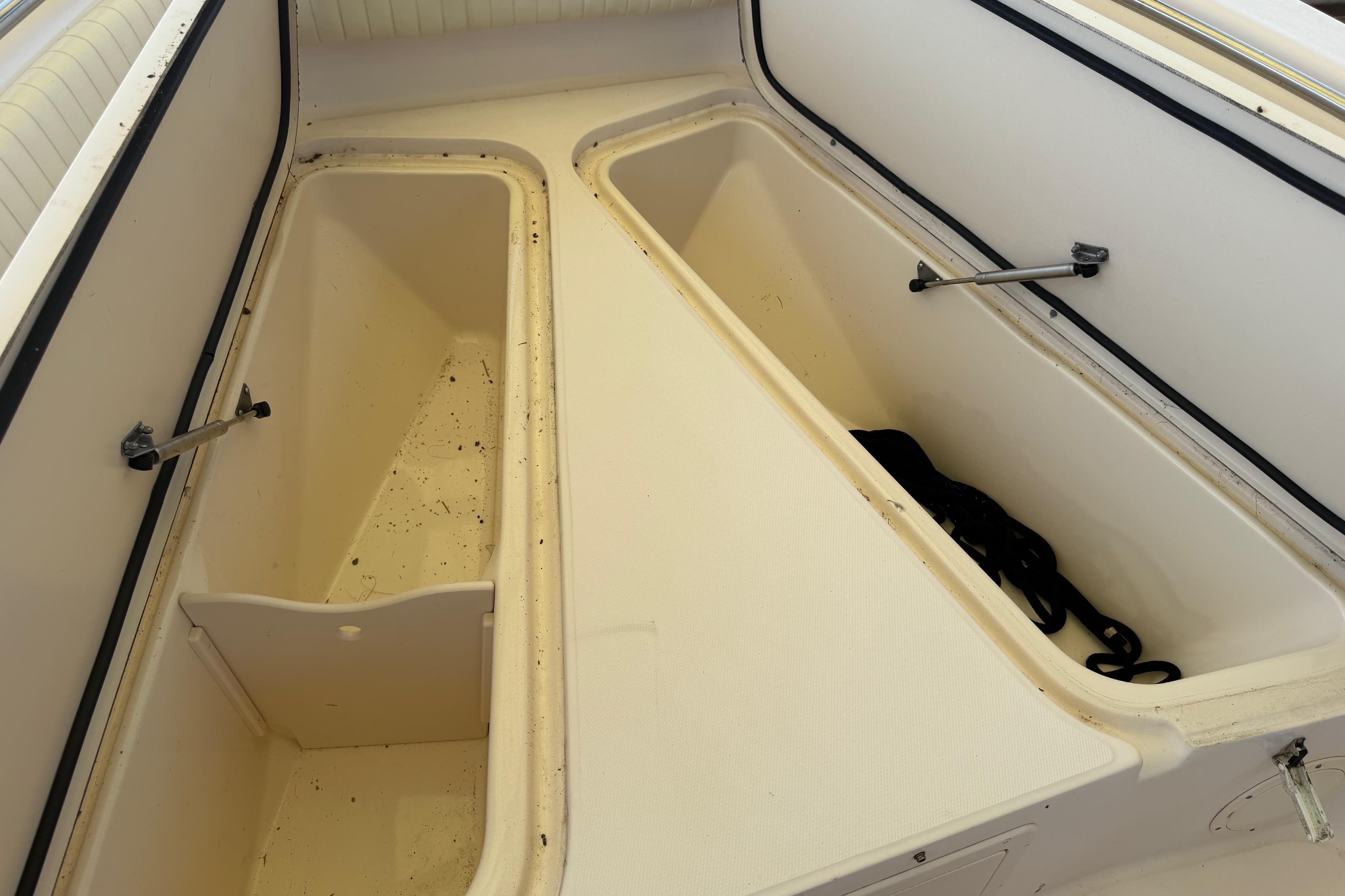 2004 Grady-White Advance 257 boat storage compartments, open and empty, showcasing interior space.