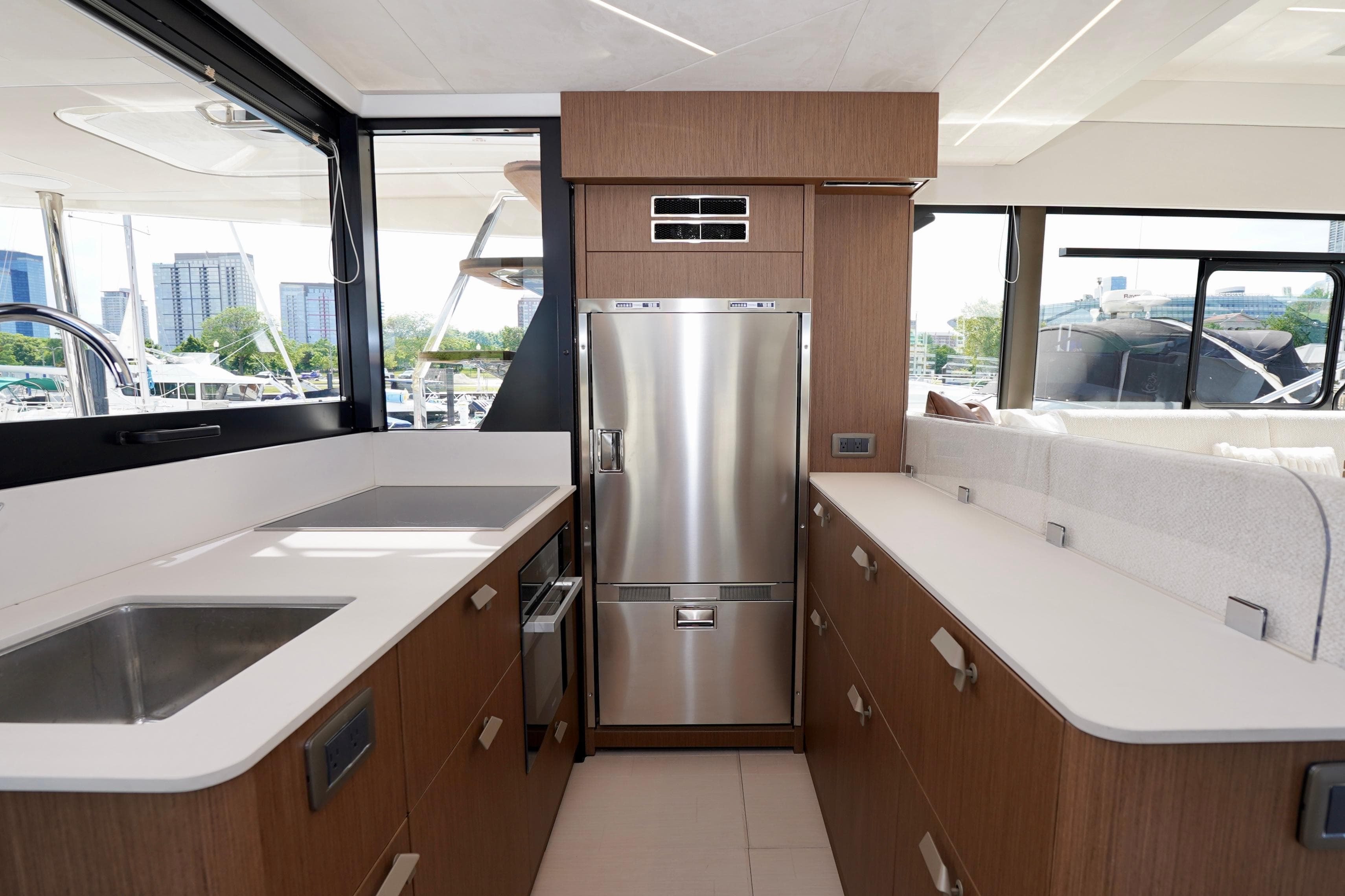 Modern yacht kitchen with stainless steel appliances, sleek countertops, and ample natural light. Prestige F5.7, 2025.