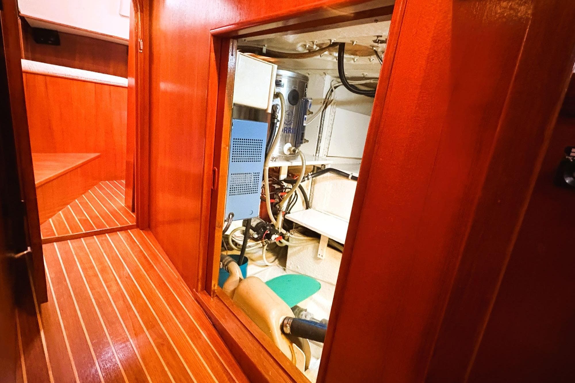 Engine room of 1980 Discovery 42 yacht with wooden interior and visible machinery.