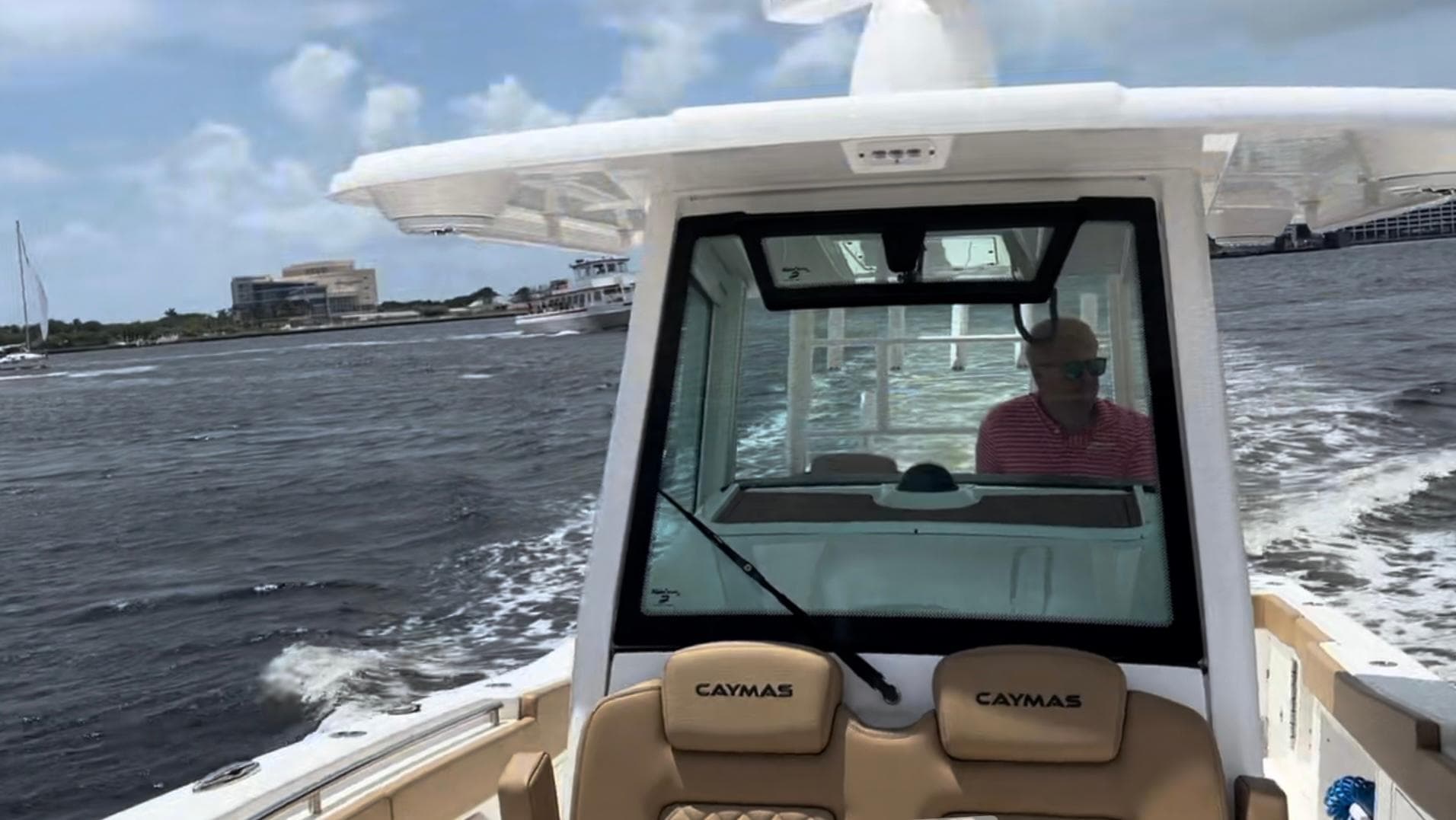 2023 Caymas 341 CC boat cruising on a sunny day with a person at the helm.