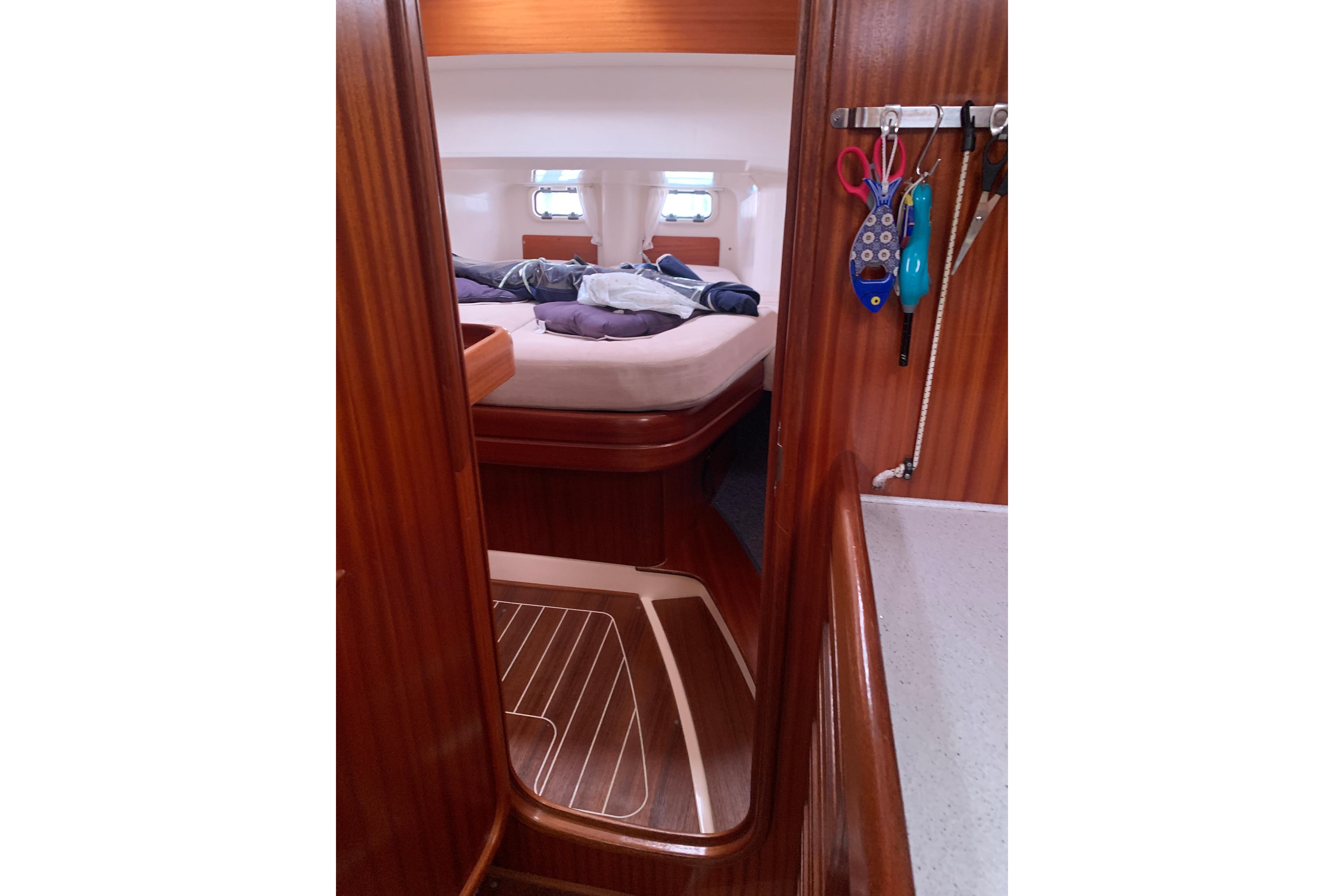 Interior of a 2000 Sunbeam 37 yacht cabin with wooden finish and cozy bed.