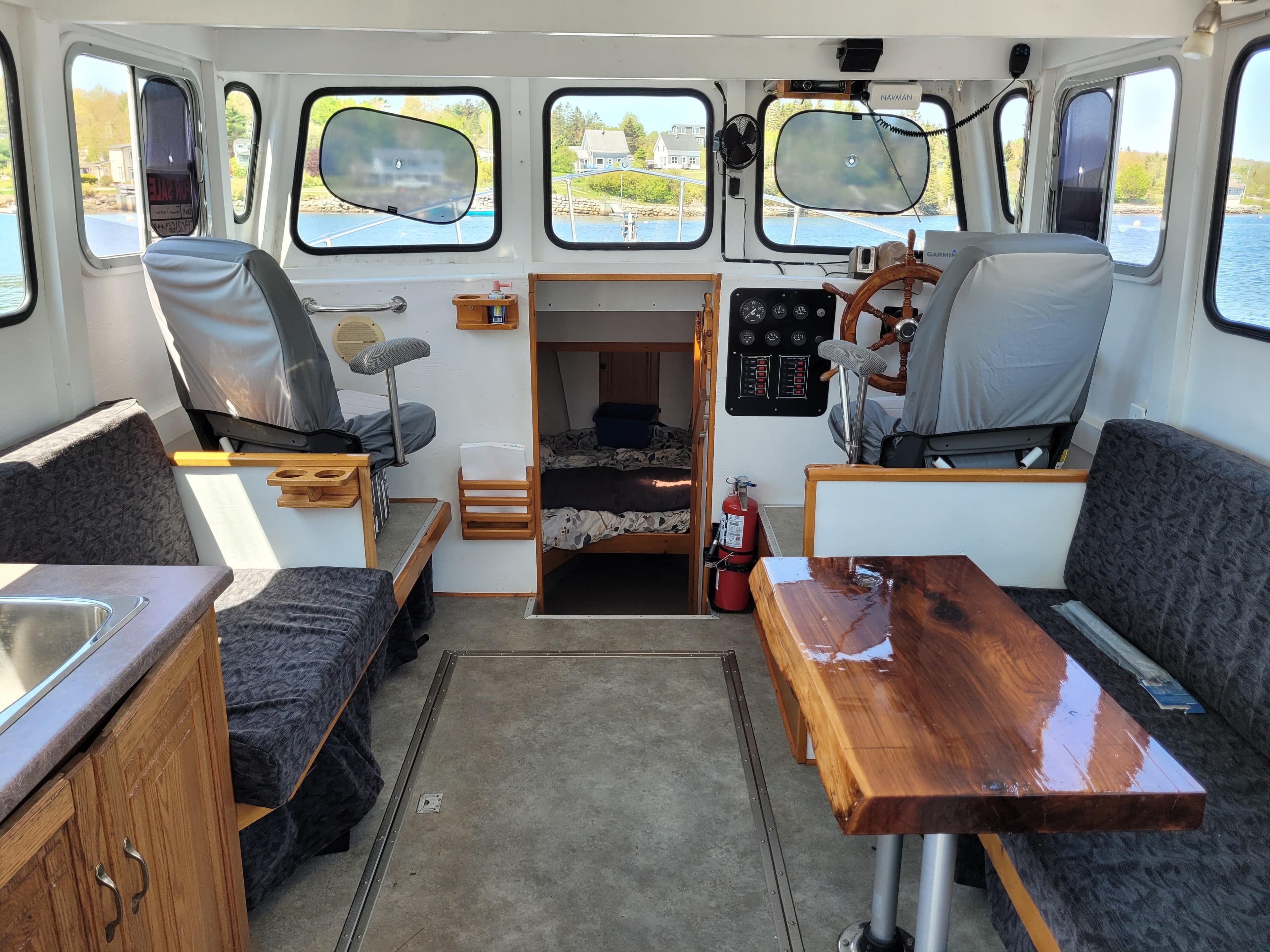 Interior of 2009 Deschamp & Jackson Cape Island 32 boat with seating, table, and helm.