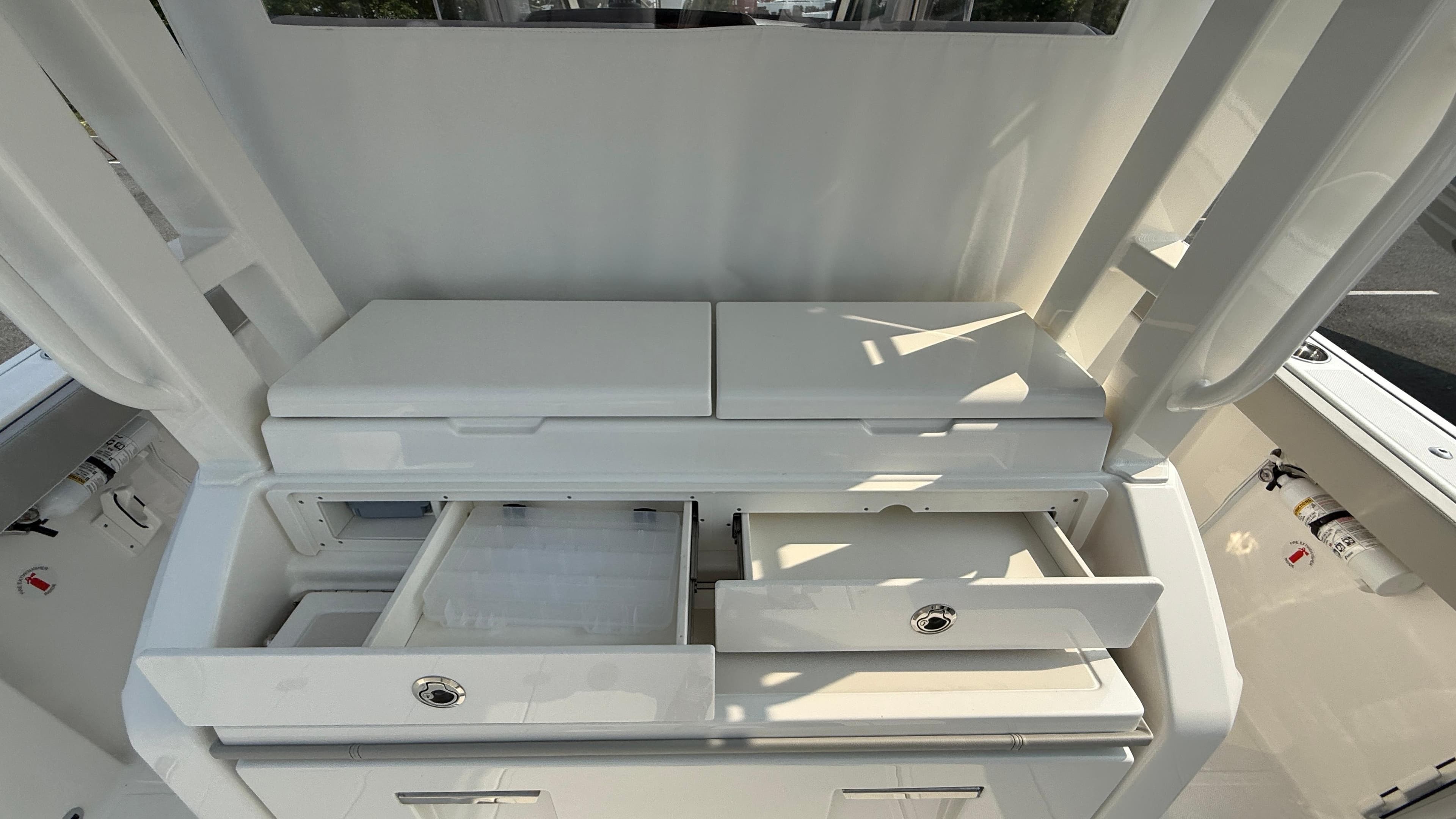2025 Pursuit S 328 Sport boat interior with open storage compartments and drawers.