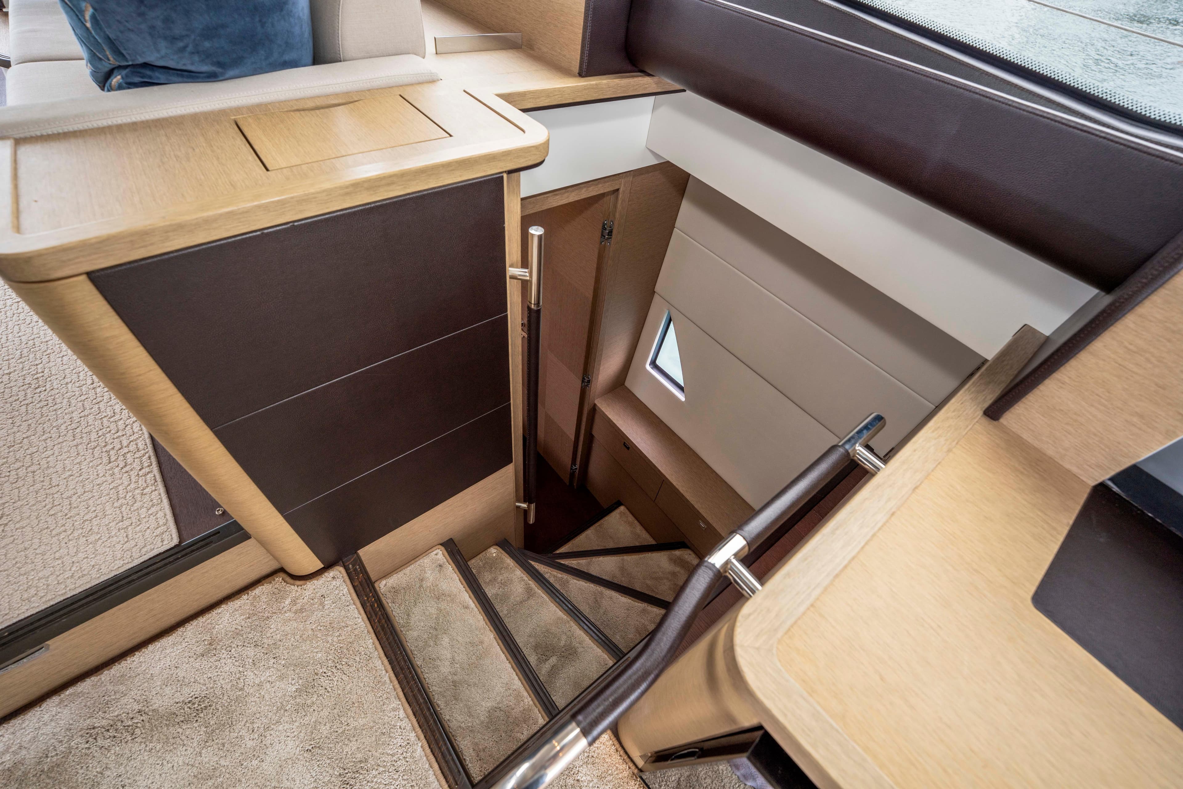 Staircase inside 2018 Prestige 560 yacht, featuring modern wood and leather design.