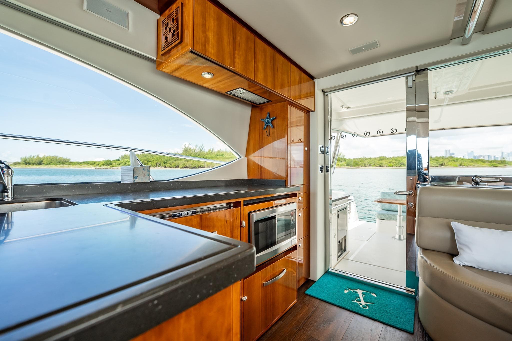 Luxurious interior of 2016 Riviera 5000 Sport Yacht with modern kitchen and scenic water view.