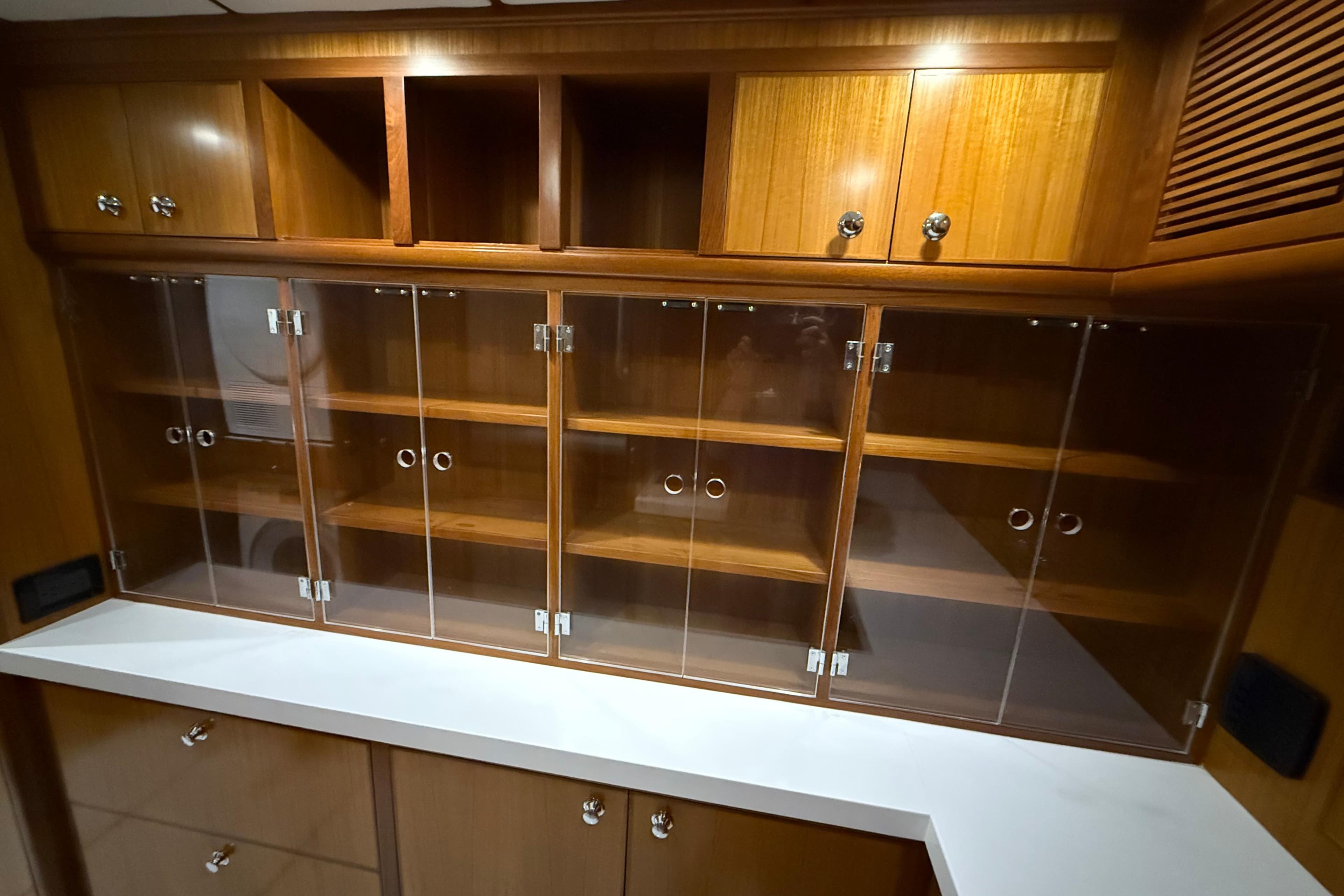 Wooden cabinetry with glass doors in a 2009 Nordhavn N64 yacht interior.