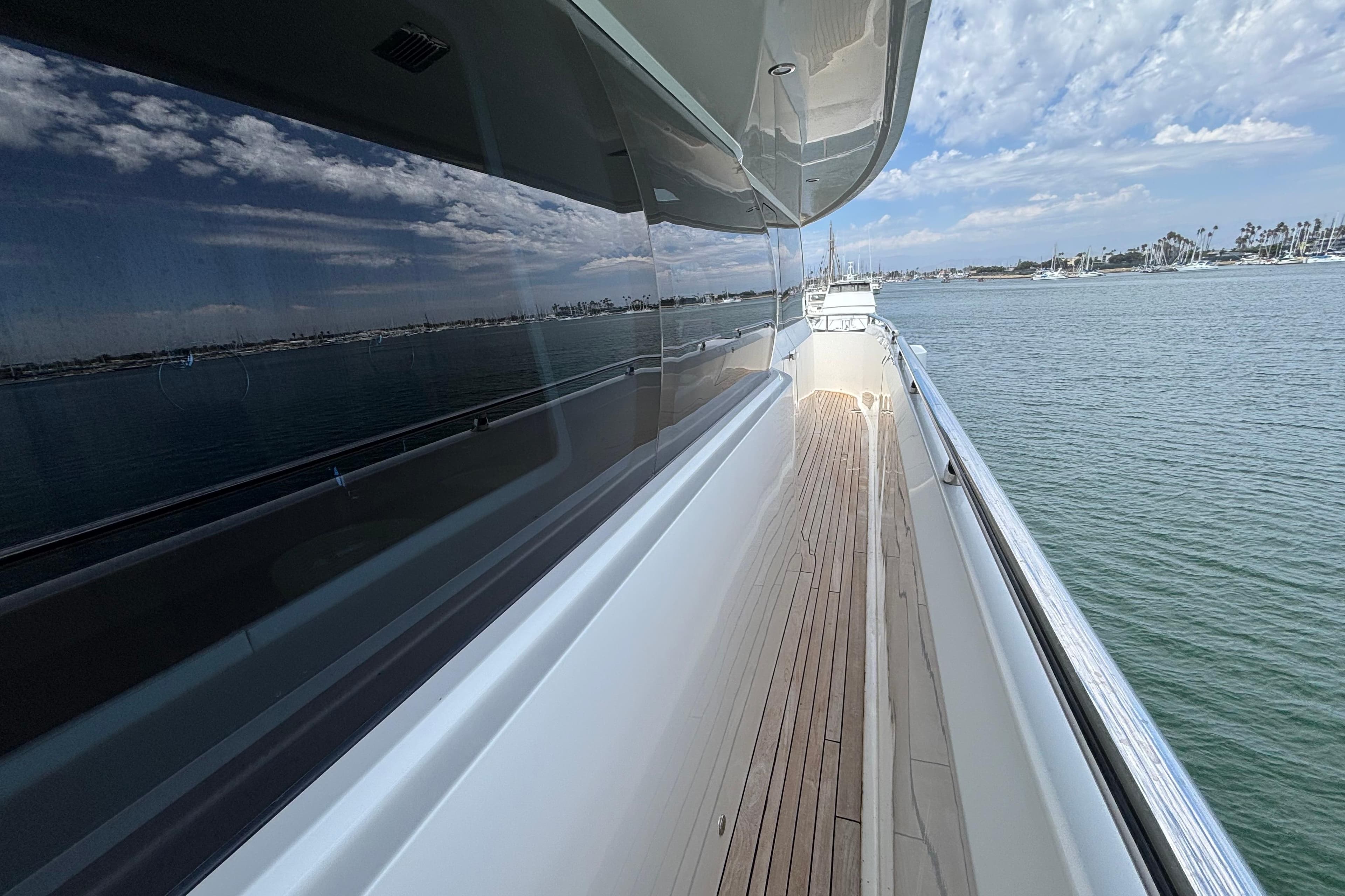 Side deck view of 2010 Norseman 80 yacht with ocean and sky reflections.