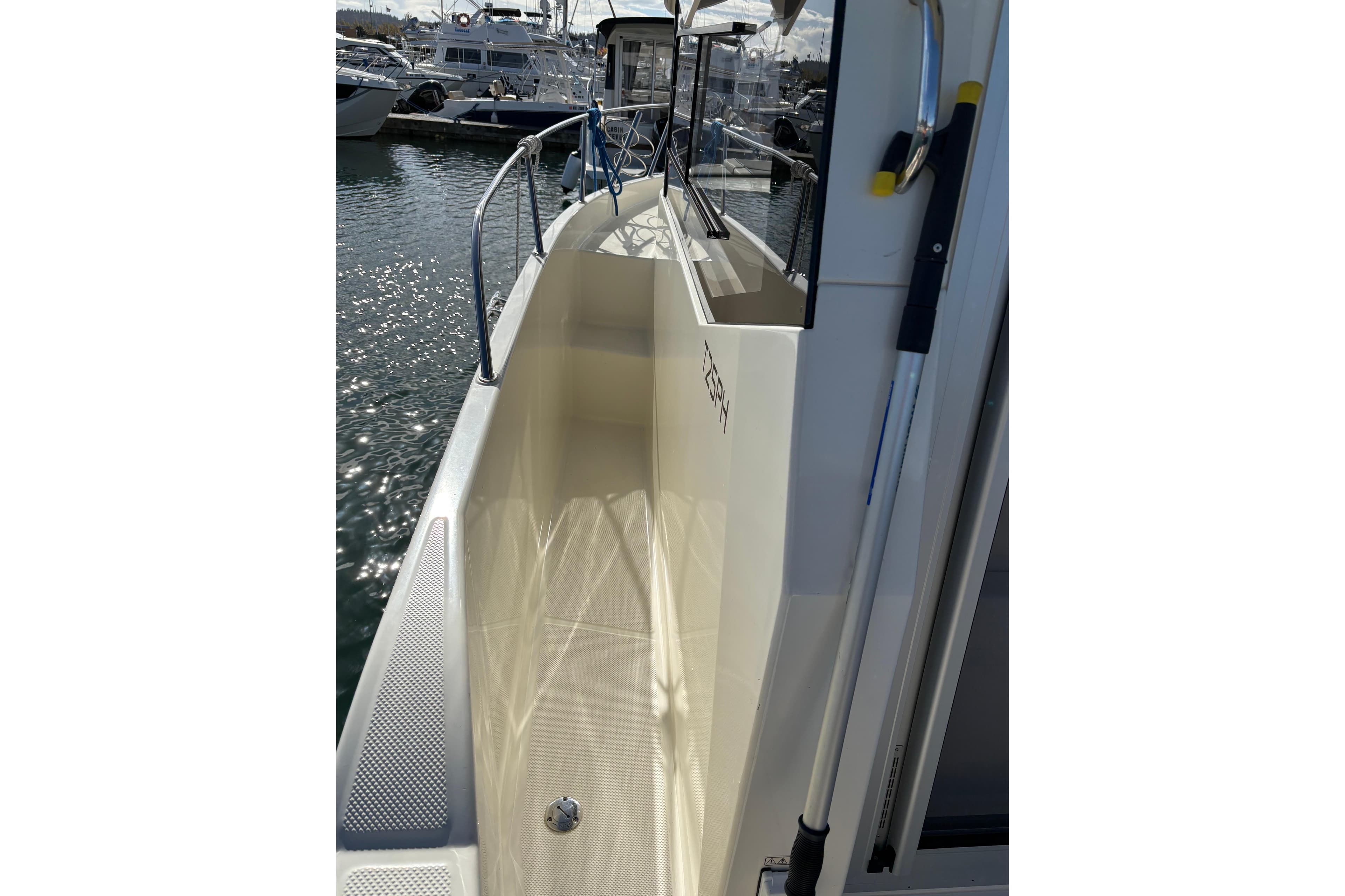 2023 Bayliner Trophy T25 Pilothouse boat docked, showcasing sleek side deck design.