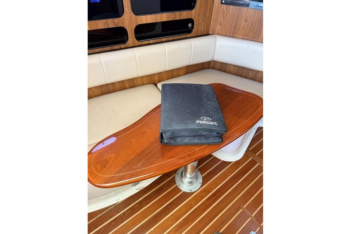 Interior of 2009 Pursuit OS 375 Offshore with wooden table and seating.