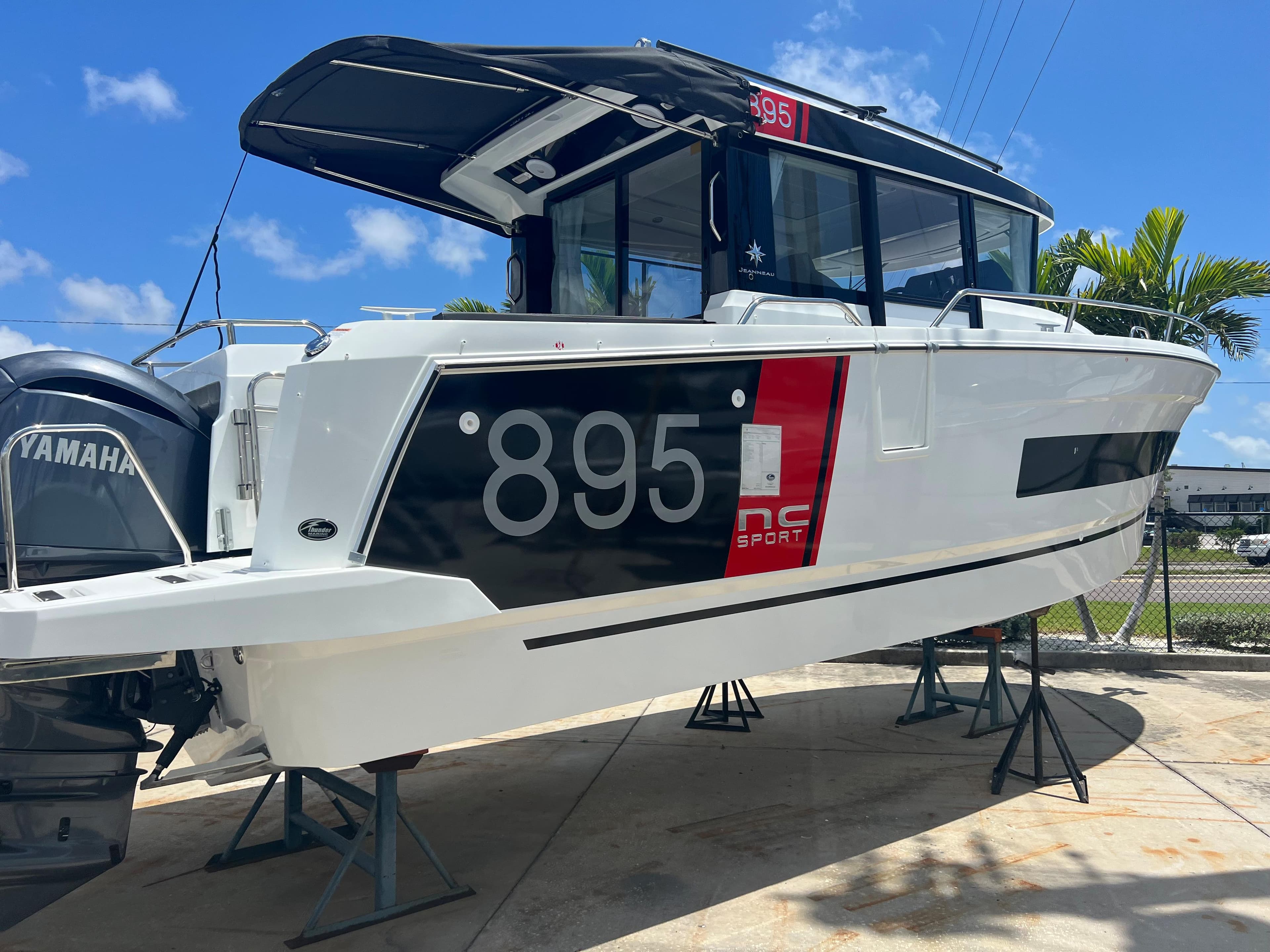 2024 Jeanneau NC Sport 895 boat on stands with Yamaha outboard motor.