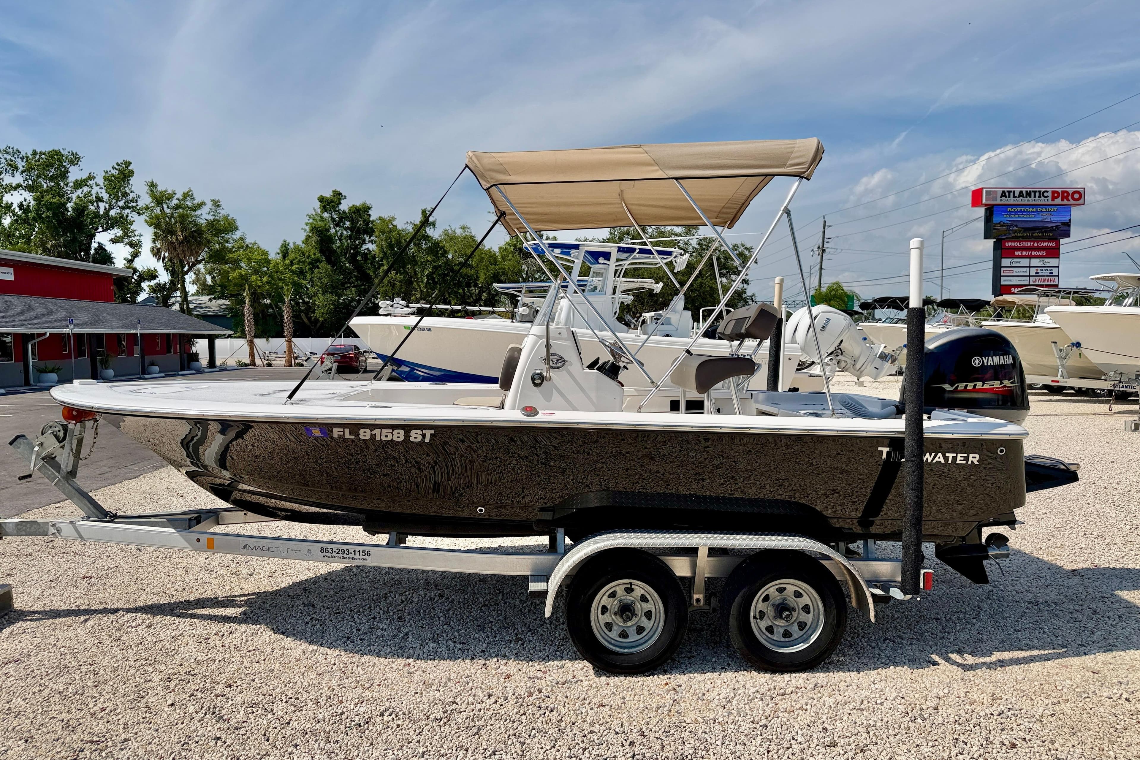 2021 Tidewater 1910 Bay Max boat on trailer, parked outdoors under clear sky.