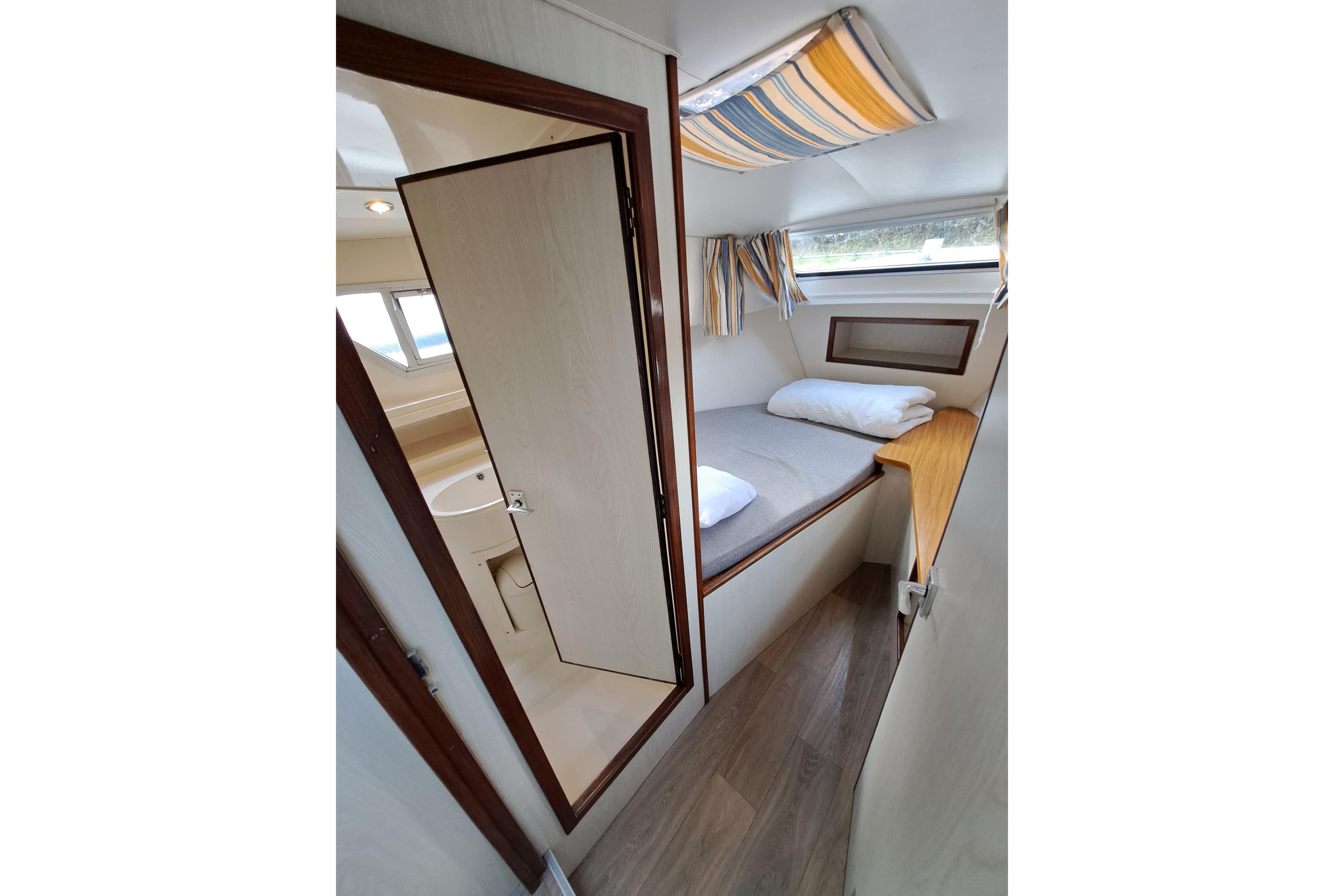 Interior of a 1999 Le Boat Corvette with bed and bathroom.