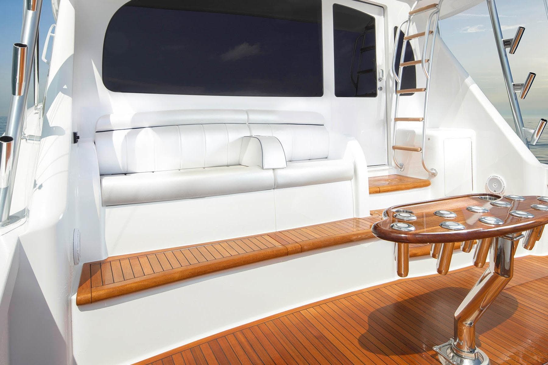 2026 Viking 58 Convertible yacht deck with seating and ladder, featuring sleek wood finishes.