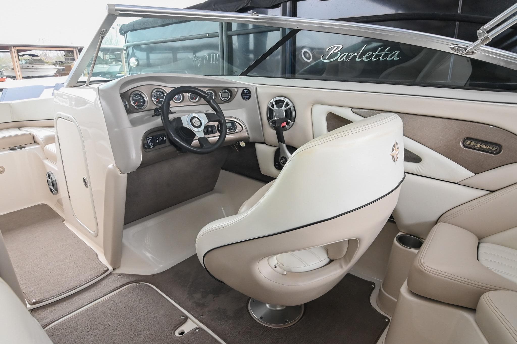 Interior of a 2007 Bryant 270 boat, featuring a sleek steering console and comfortable seating.