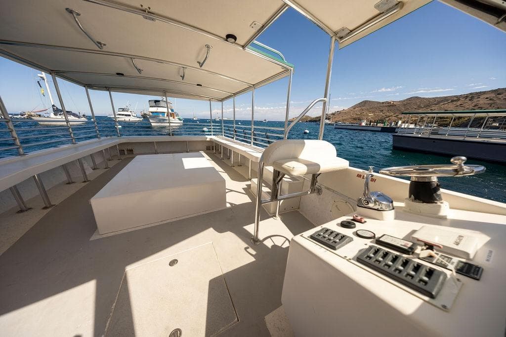 2018 Seahawk Island Hopper boat interior with control panel, docked in a scenic marina.