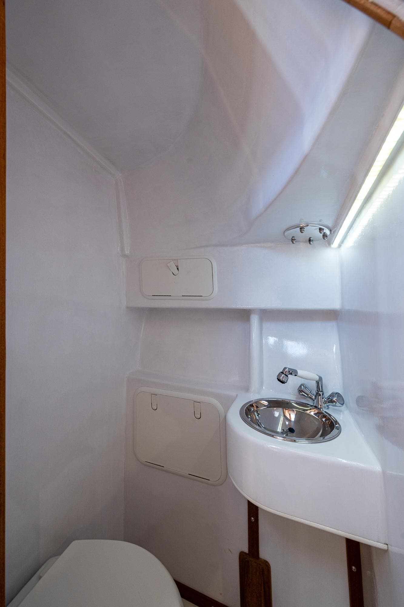 2019 Custom Carolina Custom Express boat bathroom with compact sink and storage.