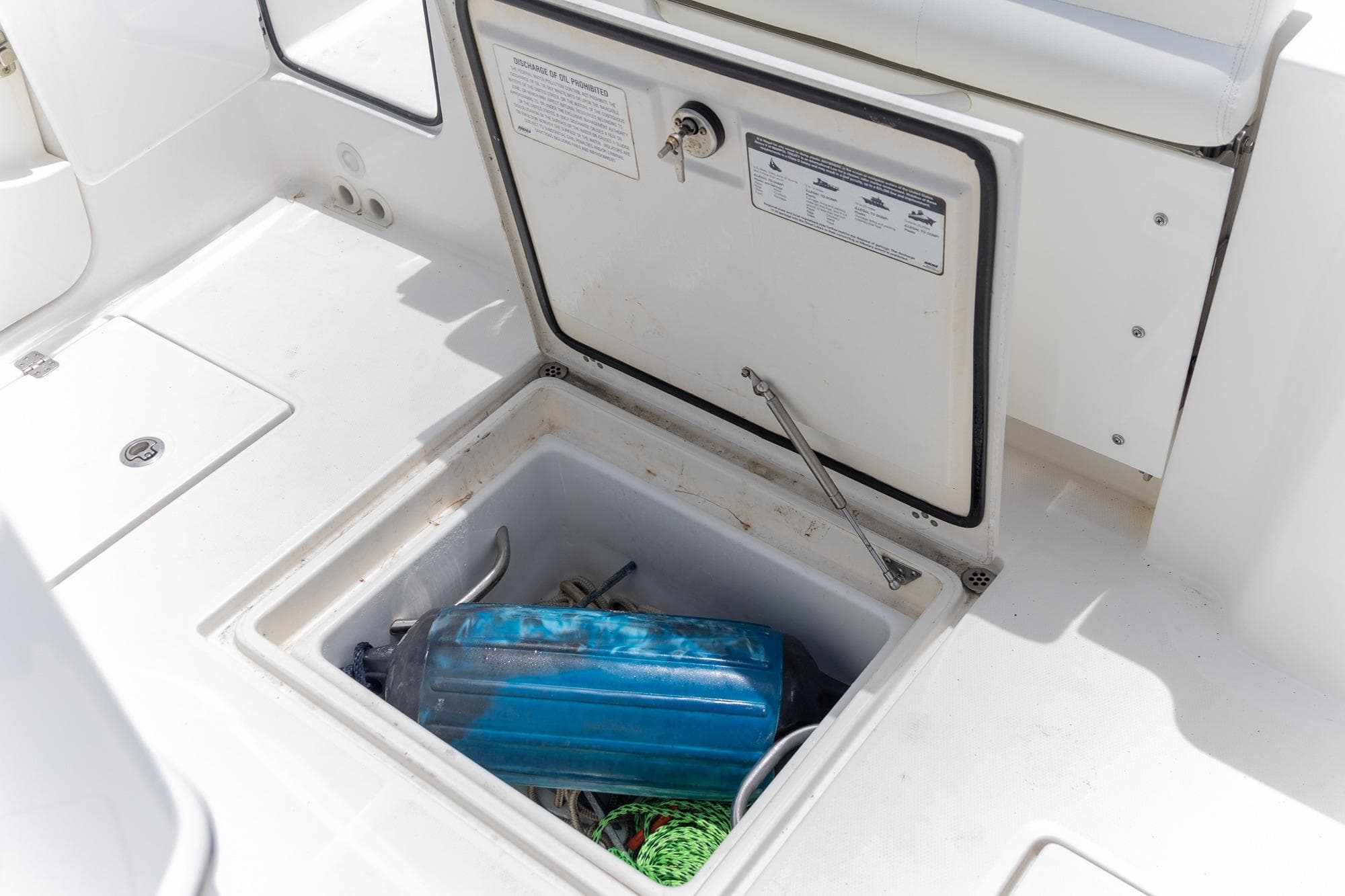 2023 Edgewater 262CC boat storage compartment with blue fender and rope.