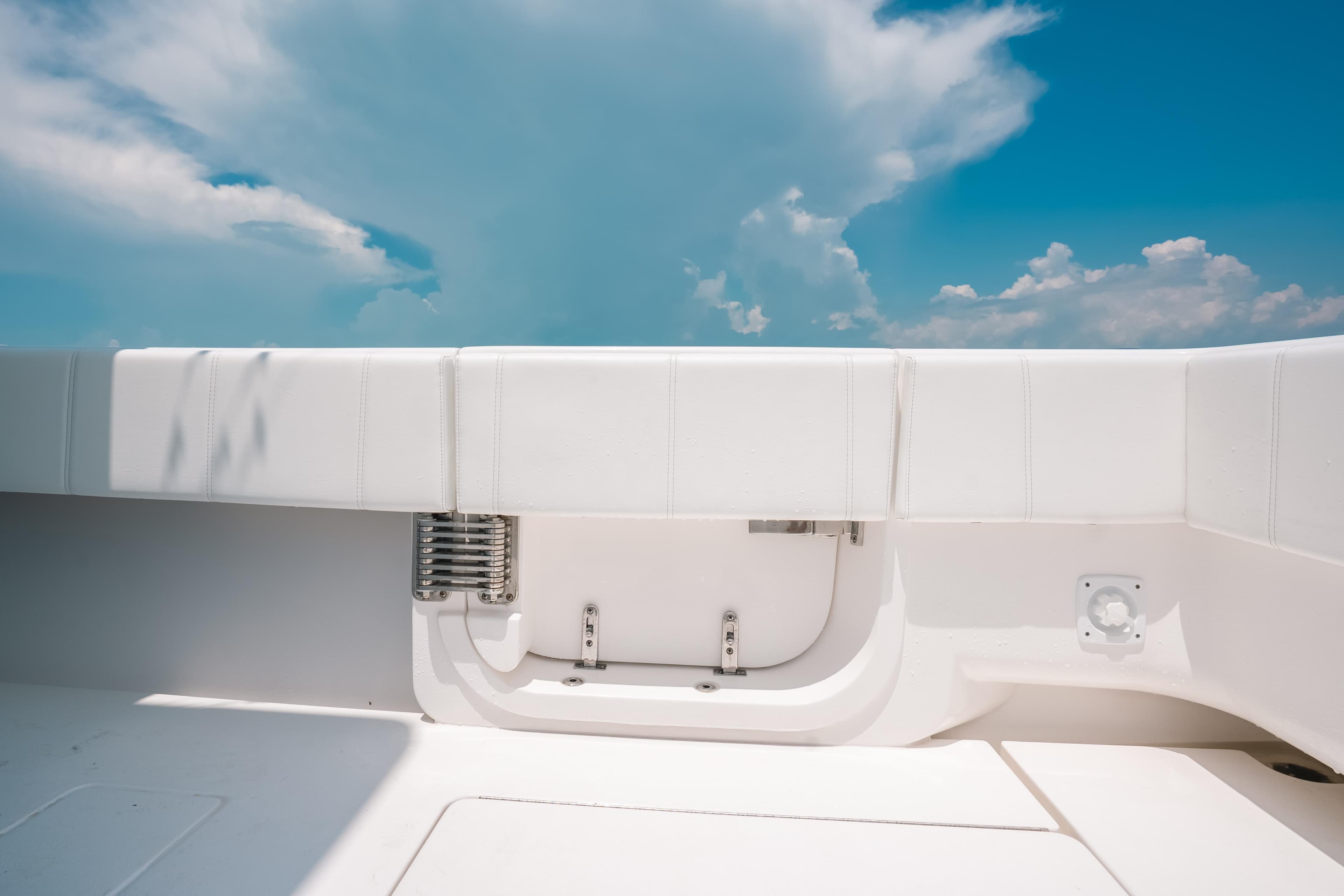 2025 Contender 44 ST boat interior with white seating under a clear blue sky.