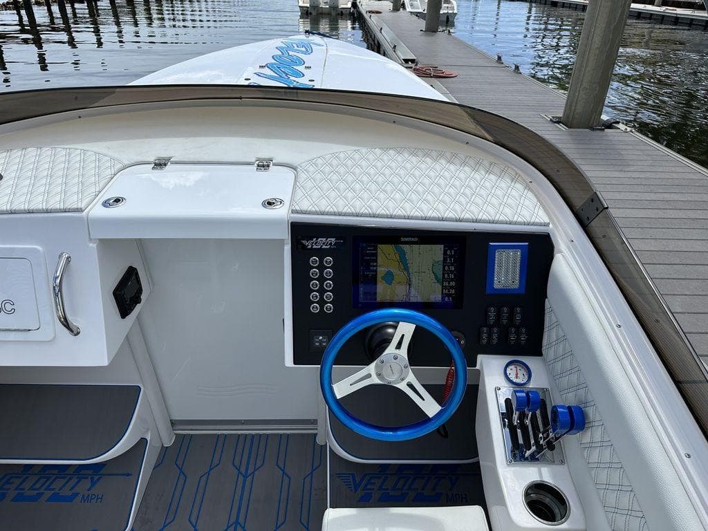 2024 Velocity 290sc boat dashboard with navigation system and blue steering wheel.