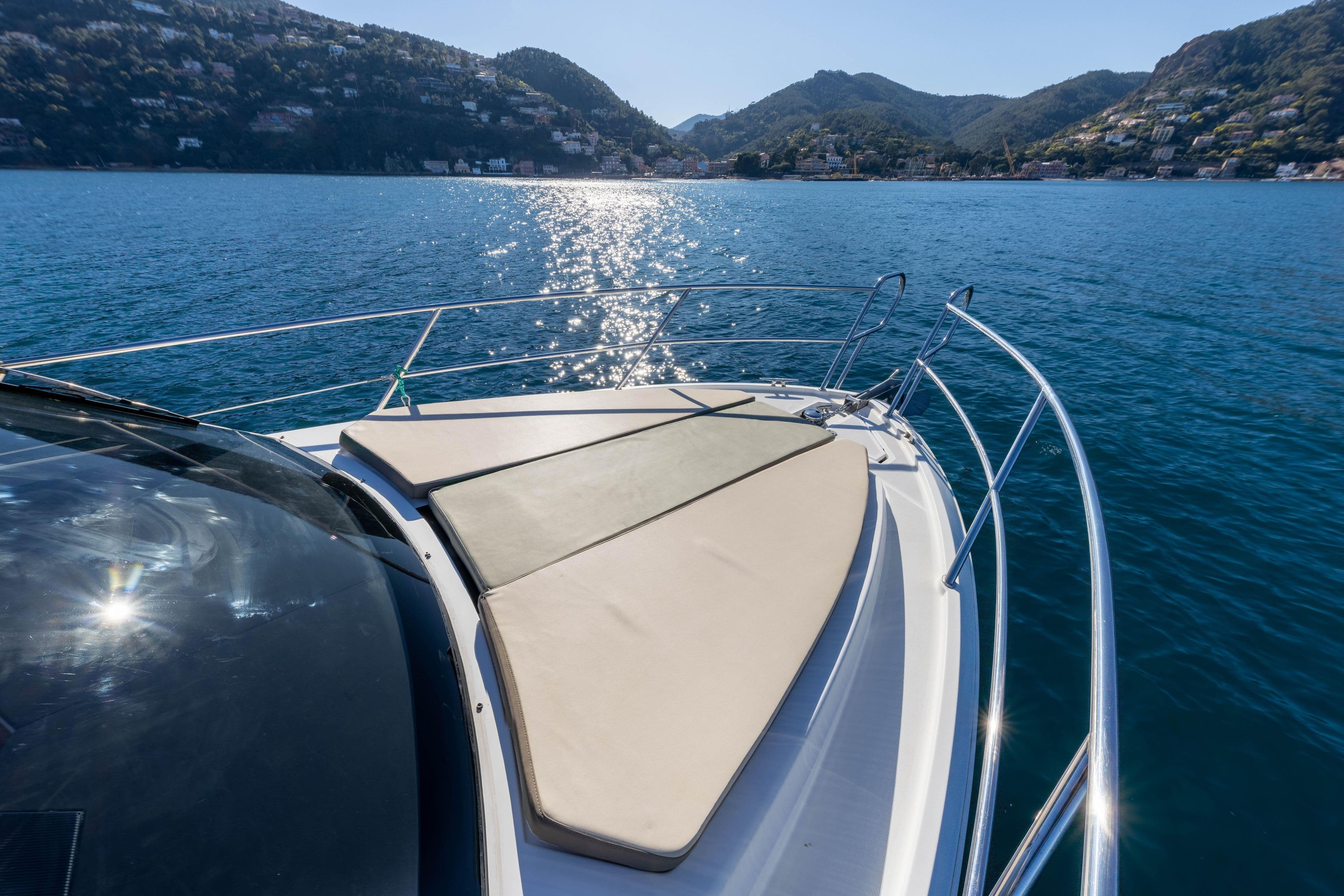 2017 Galeon 310 HTC yacht on serene blue water with scenic mountain backdrop.