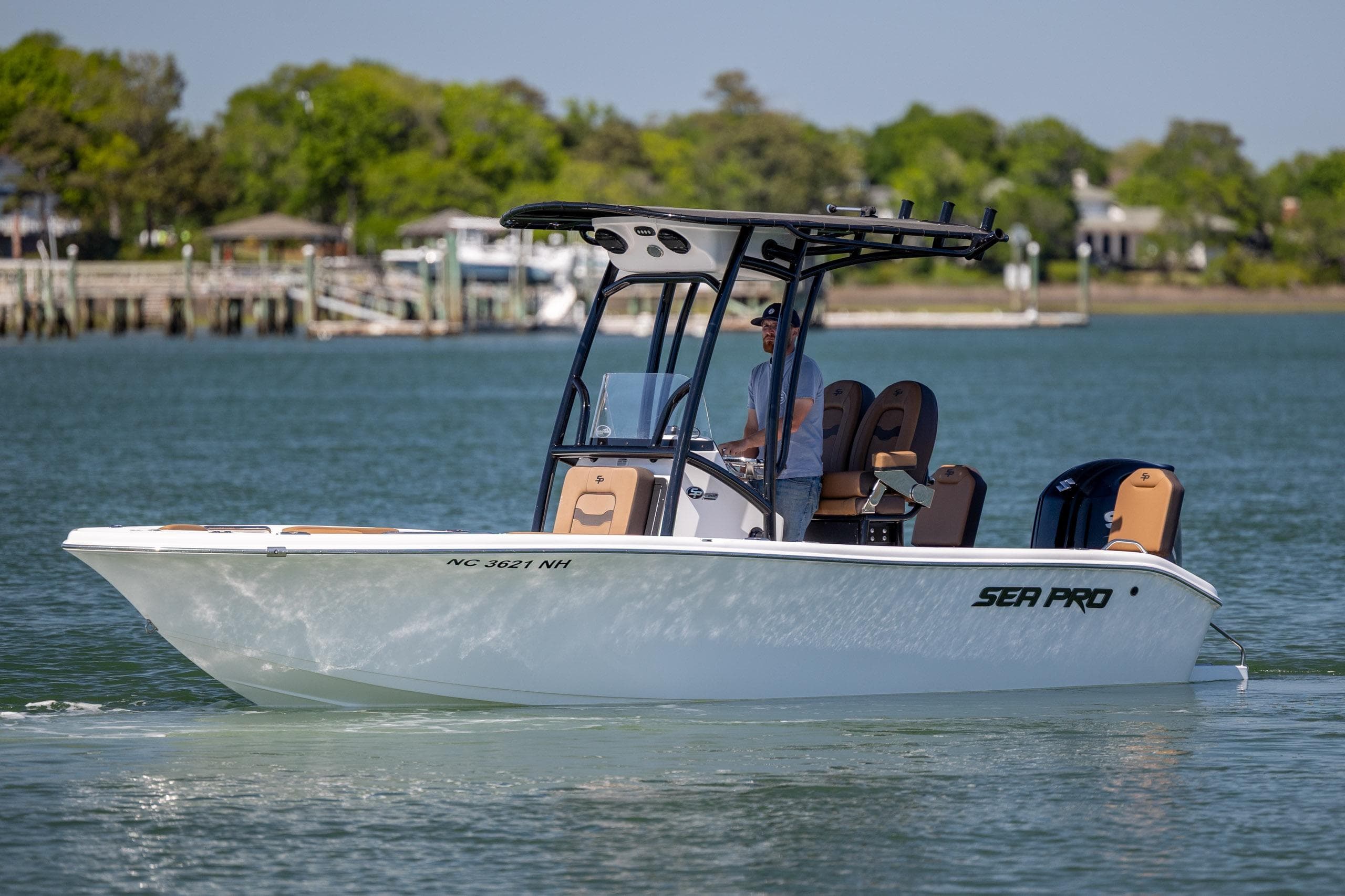 2025 Sea Pro 202 Center Console boat cruising on a calm lake with scenic background.