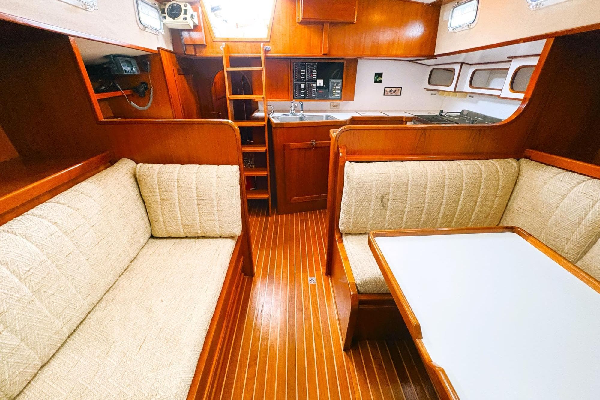 Interior of 1980 Discovery 42 yacht with wooden finish and cozy seating area.