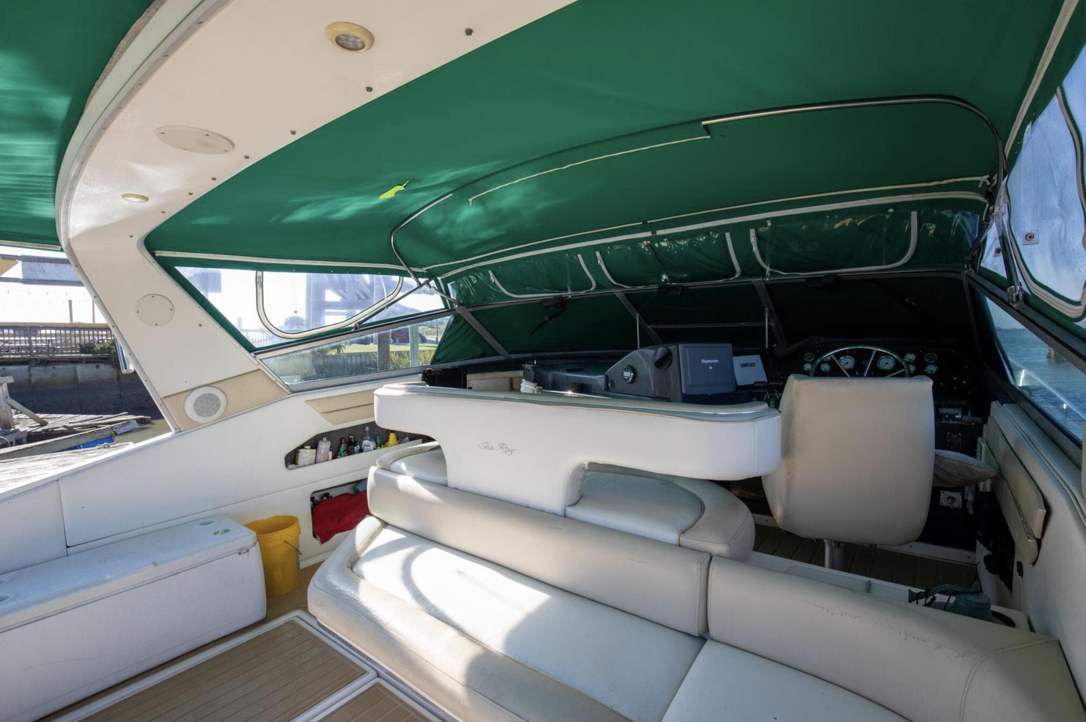 Interior of 1990 Sea Ray 420 Sundancer yacht with green canopy and white seating.