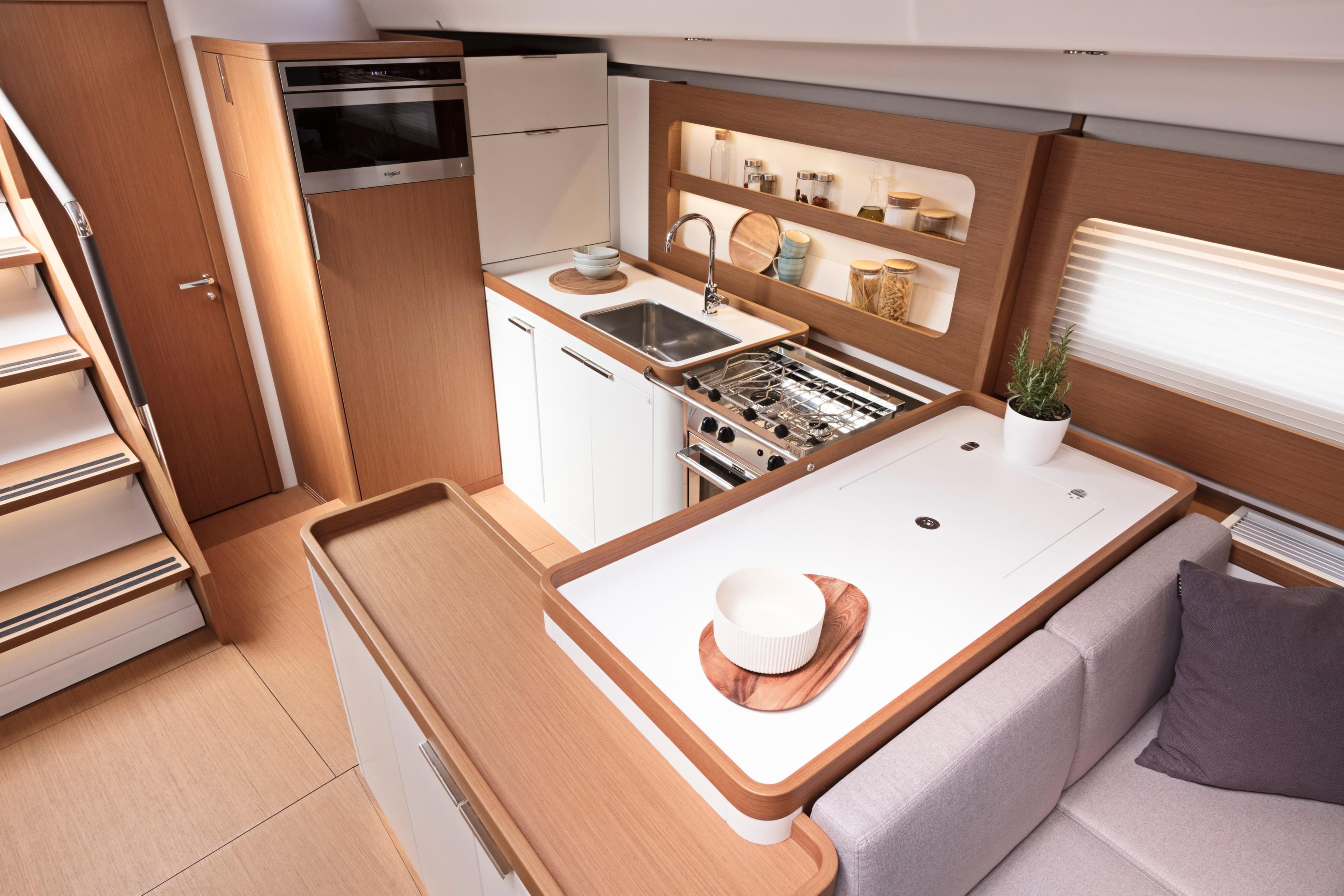 Modern kitchen interior of 2026 Beneteau First 53 yacht, featuring sleek design and wooden accents.