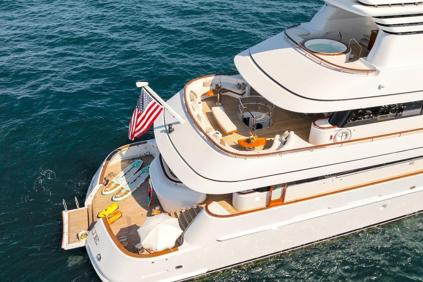 Luxurious 2001 Feadship Custom yacht with decks, American flag, and water sports gear.