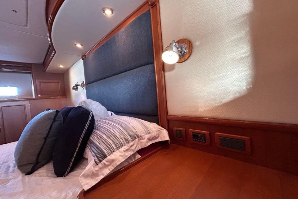 Luxurious cabin interior of 2008 Grand Banks 59 Aleutian RP yacht with plush bedding.