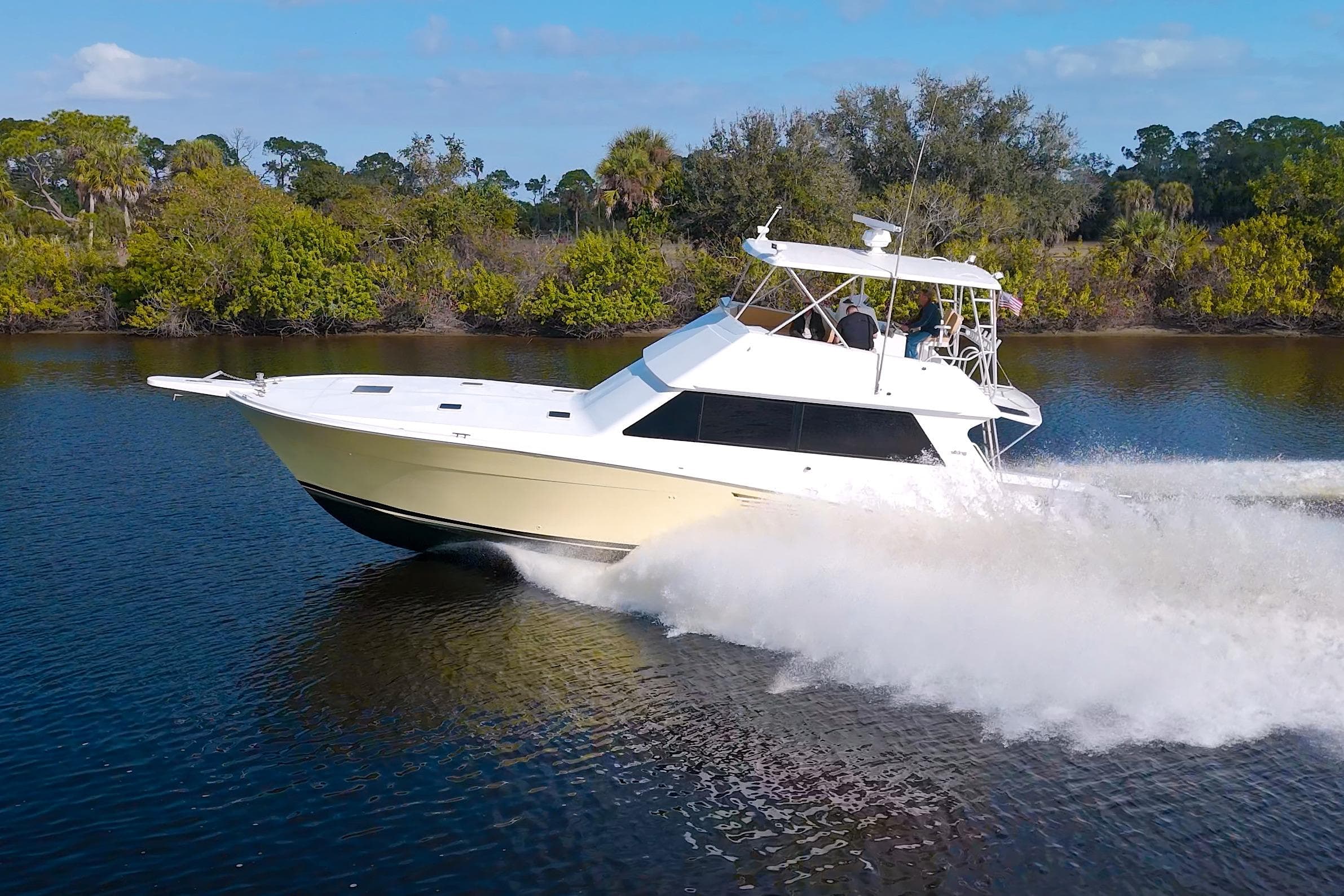 1990 Viking 53 Convertible yacht cruising on a scenic waterway.