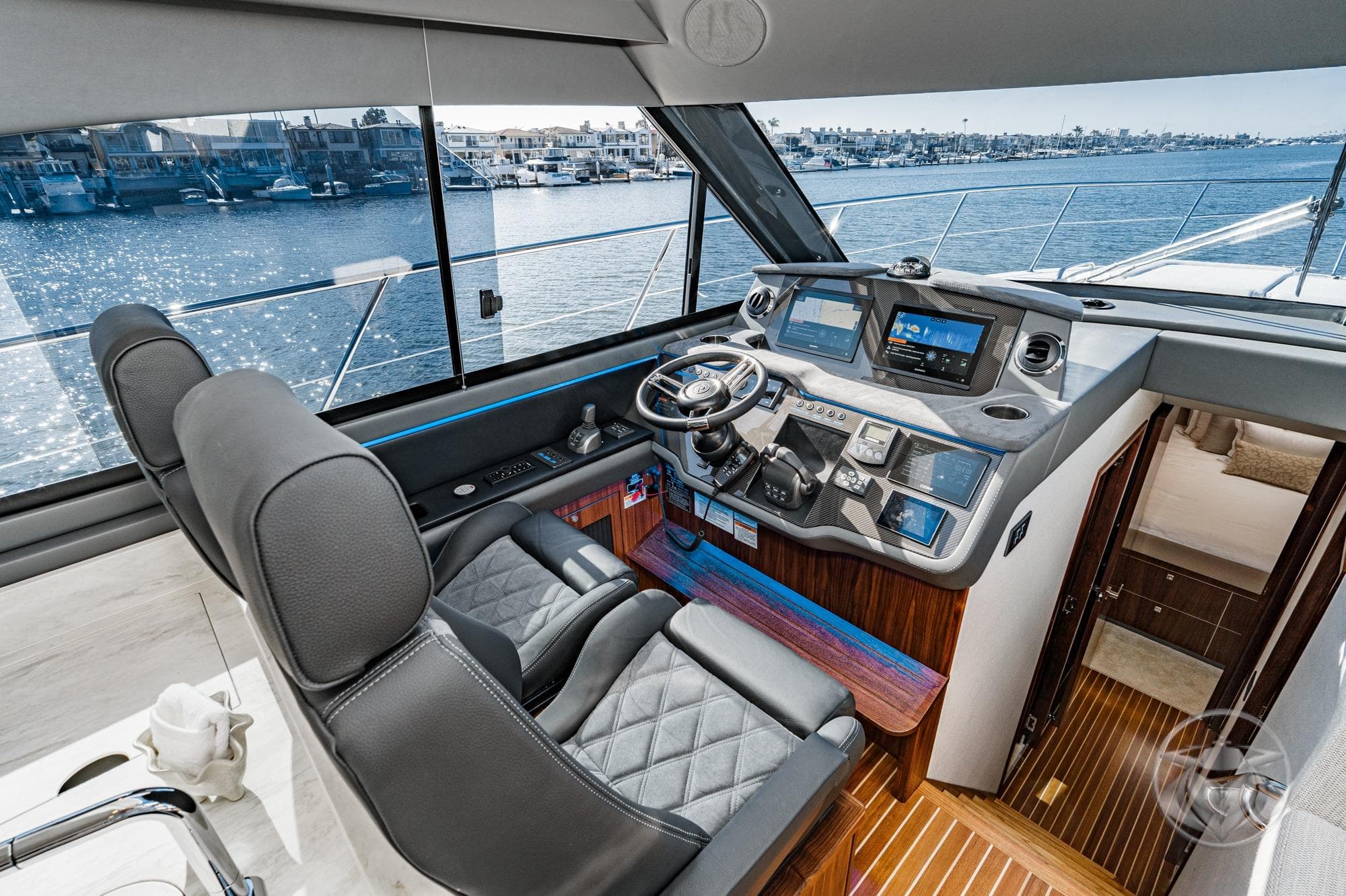 Interior of 2026 Riviera 4600 Sport Yacht Platinum Edition, featuring luxurious helm and waterfront view.