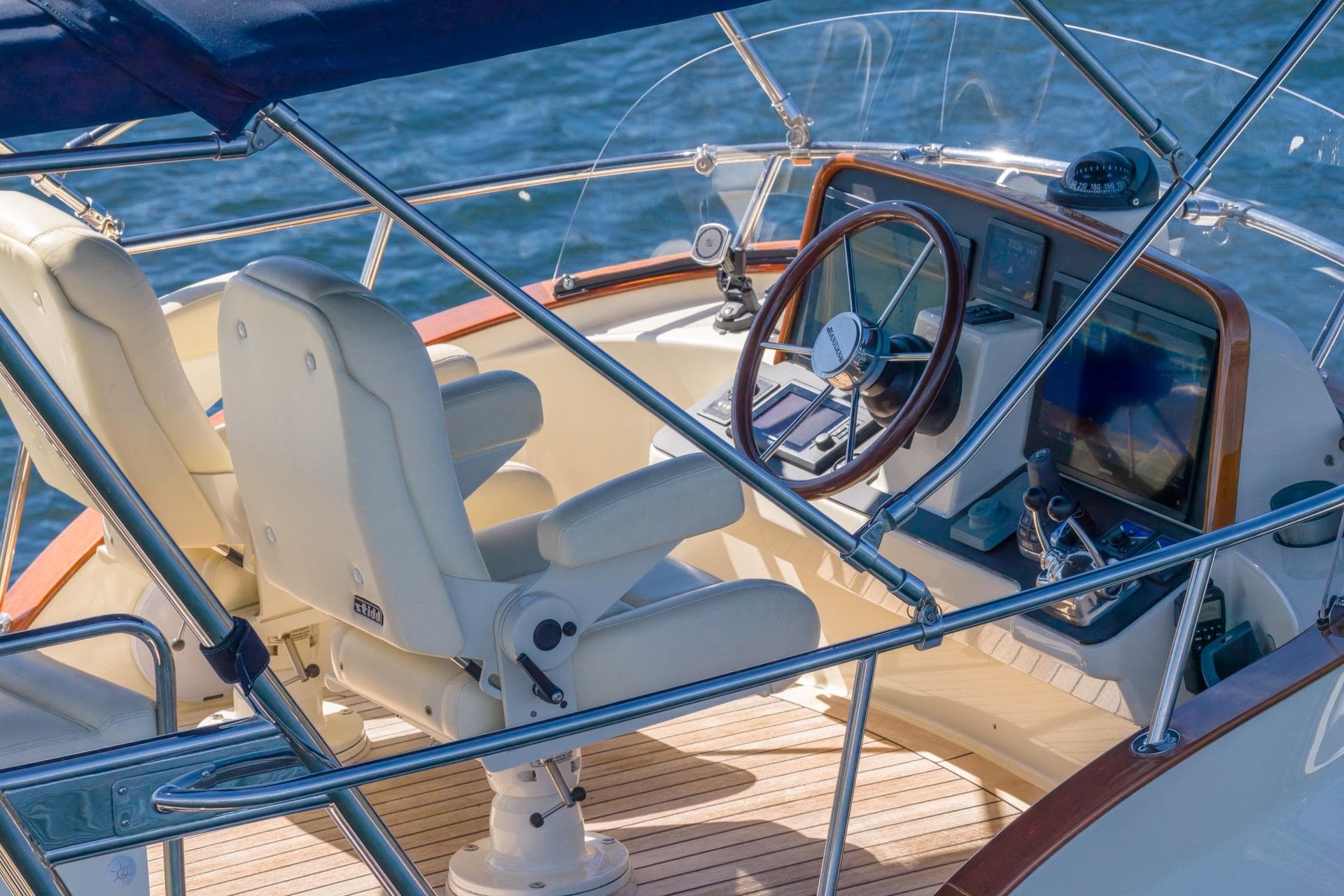 Luxurious helm of 2010 San Juan SJ40FB IPS yacht with dual seats and navigation controls.