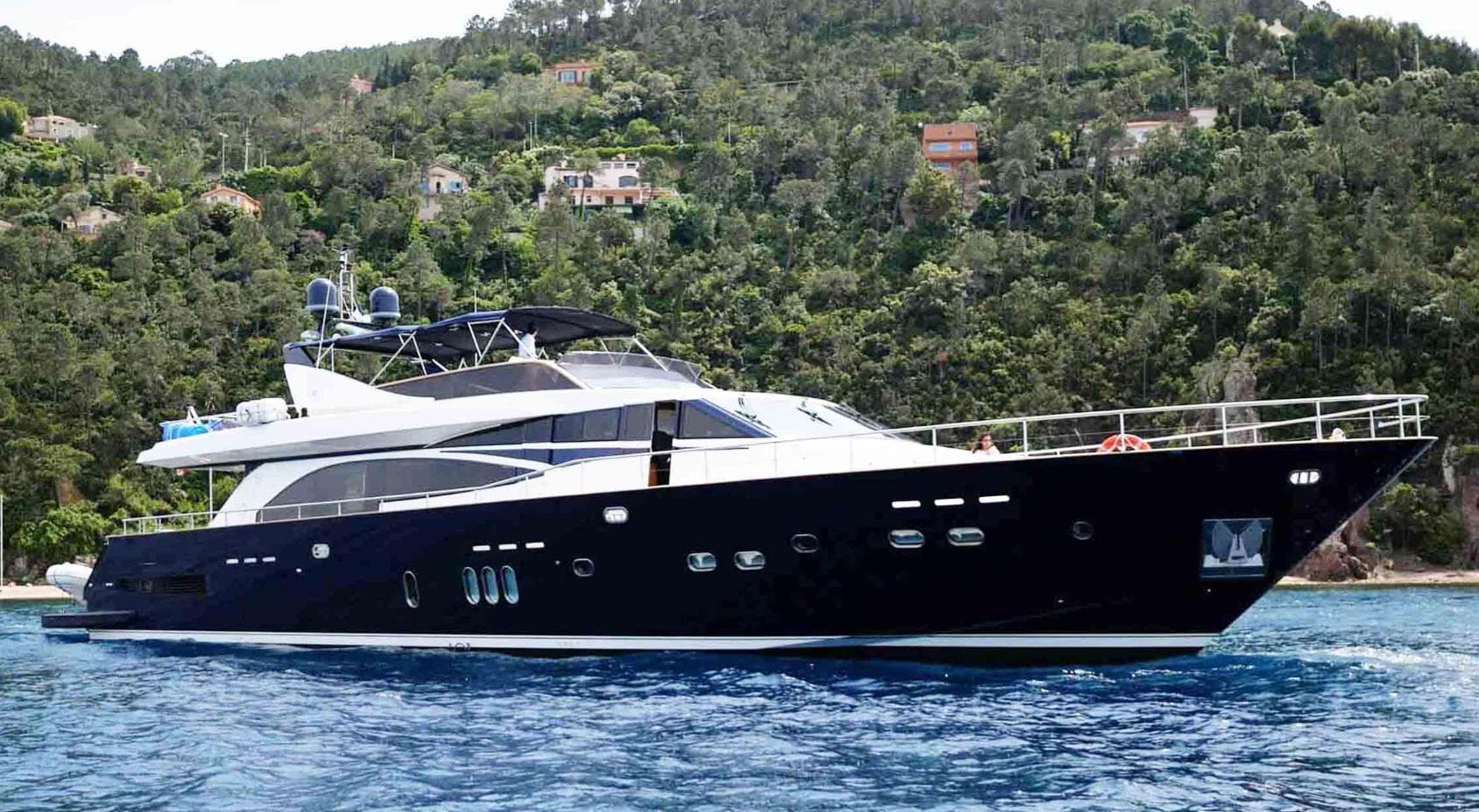 Luxury 2006 Couach 3000 Fly yacht cruising near lush, green coastline.