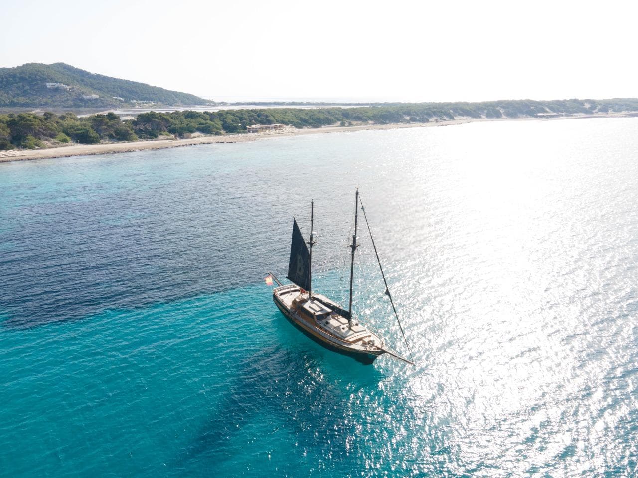 Gulet Meler 1994 sailing in clear turquoise waters near a scenic coastline.