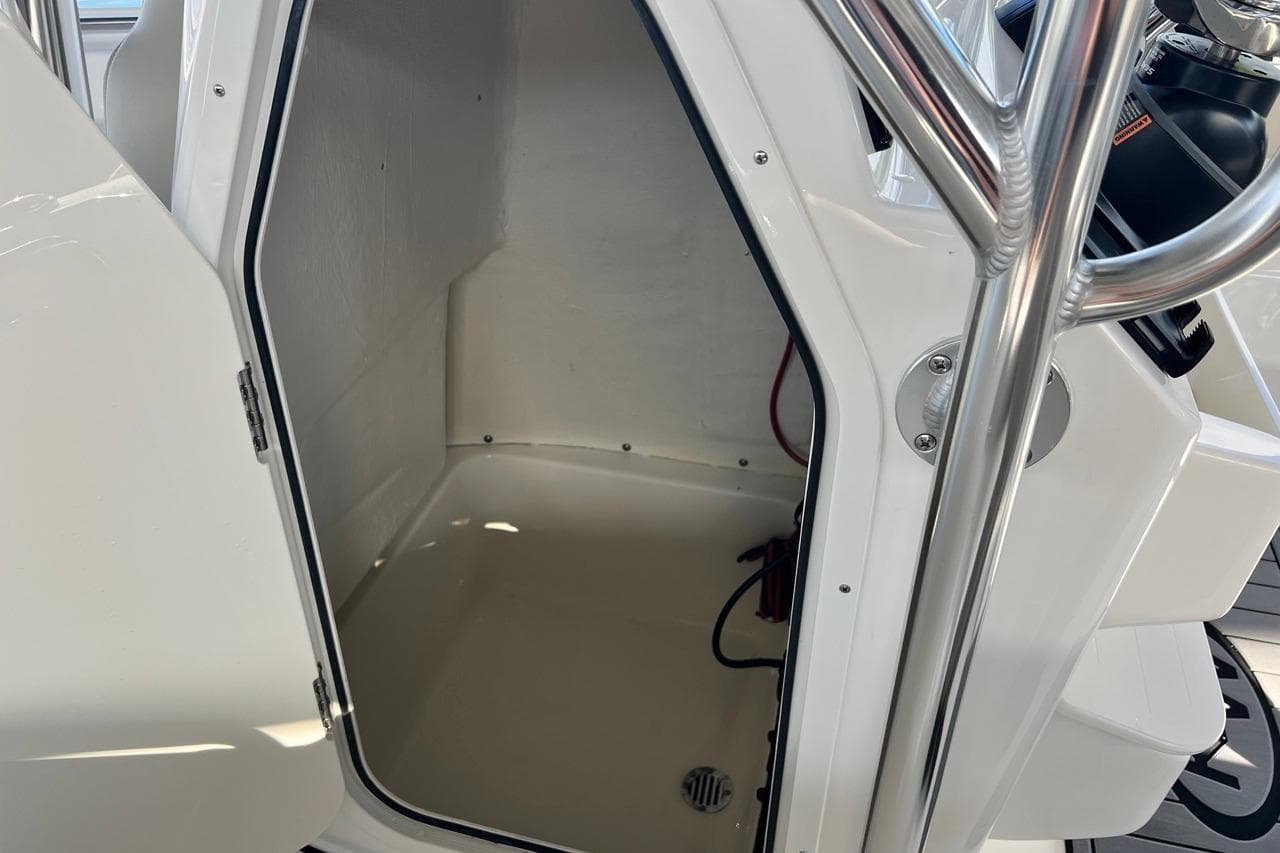 2026 Key West 189 FS boat storage compartment with open door and stainless steel railing.