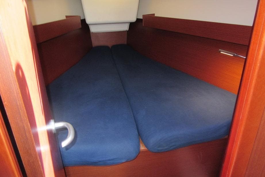 Cozy cabin interior of 2022 Dehler 34 yacht with blue cushions.