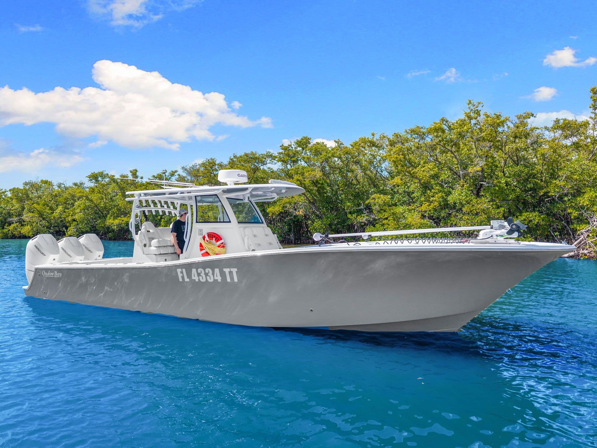 2024 Onslow Bay 37 TE boat on blue water with trees in background.