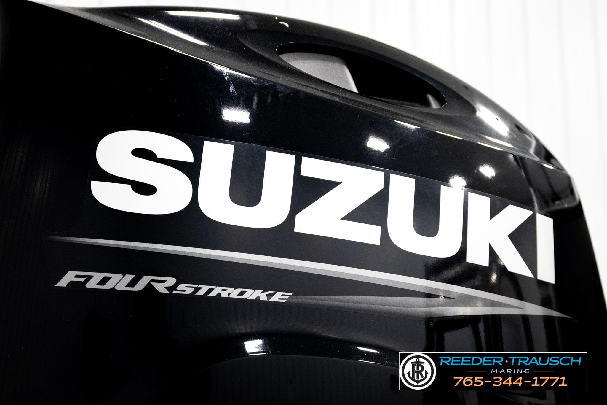 Suzuki four-stroke engine close-up, featuring Reeder Trausch Marine branding.