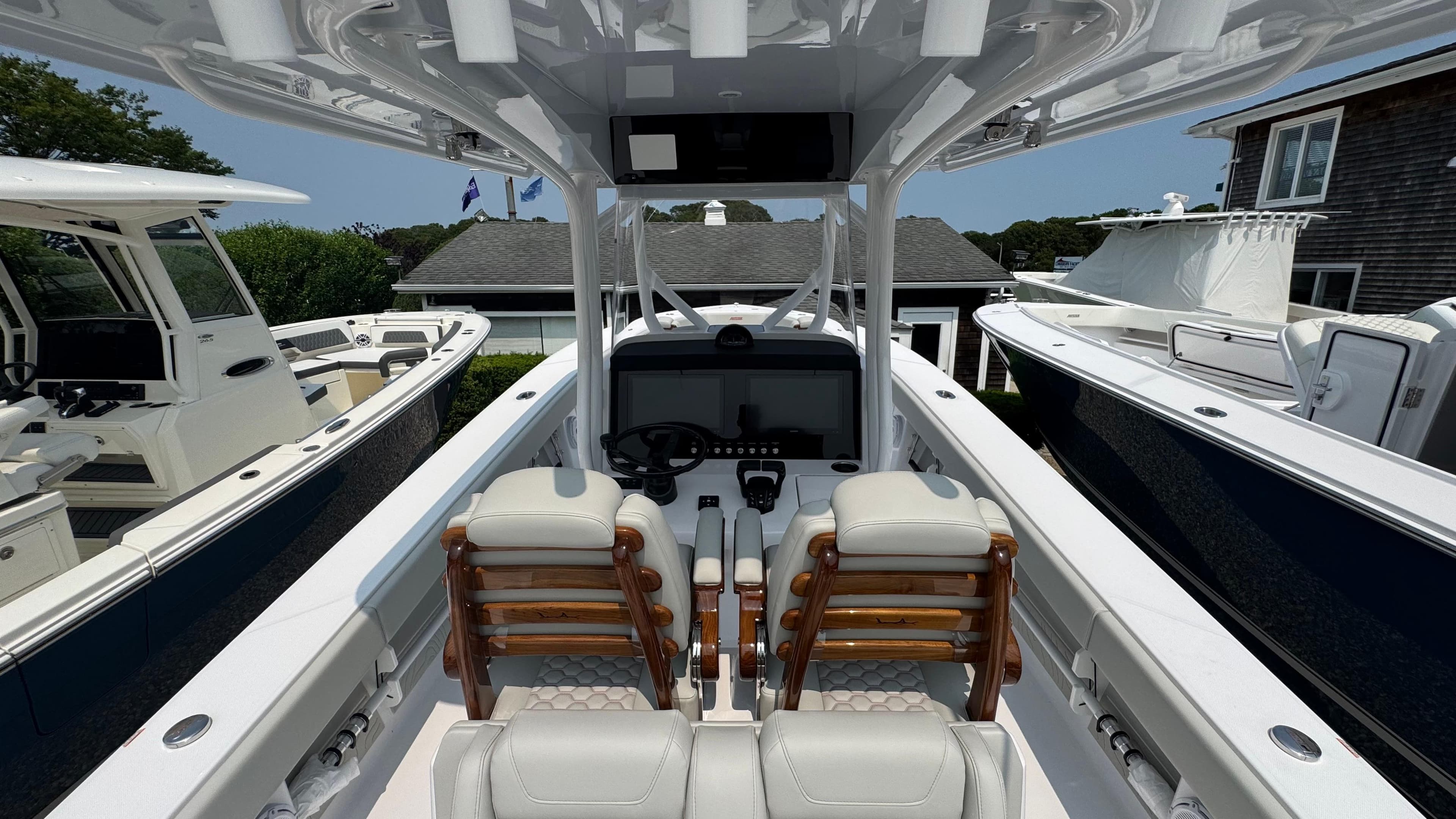 2026 Jupiter 32 boat interior with dual seats and modern dashboard, docked alongside other boats.