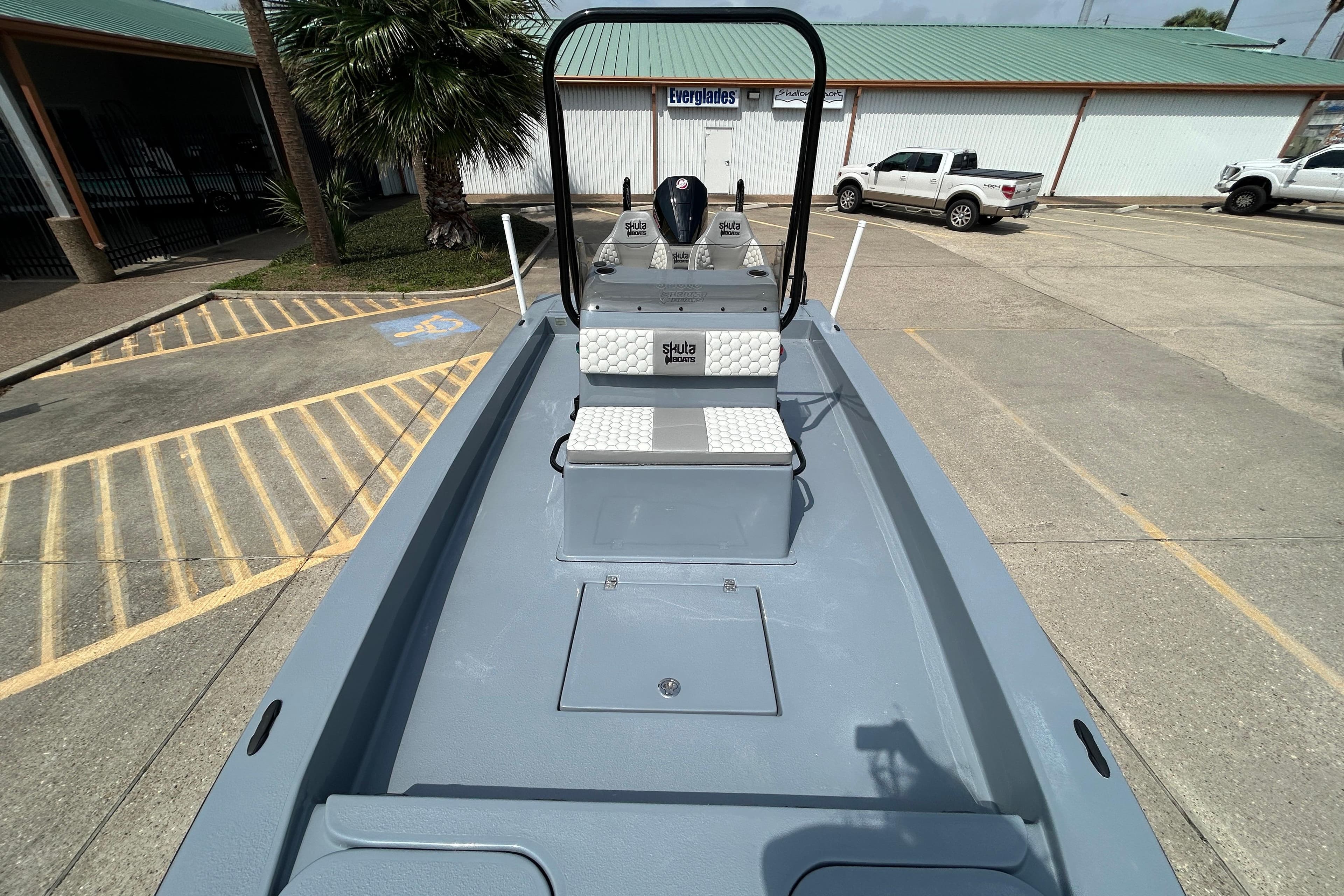 2026 Skuta 24 Vista boat in parking lot, showcasing sleek design and spacious deck.