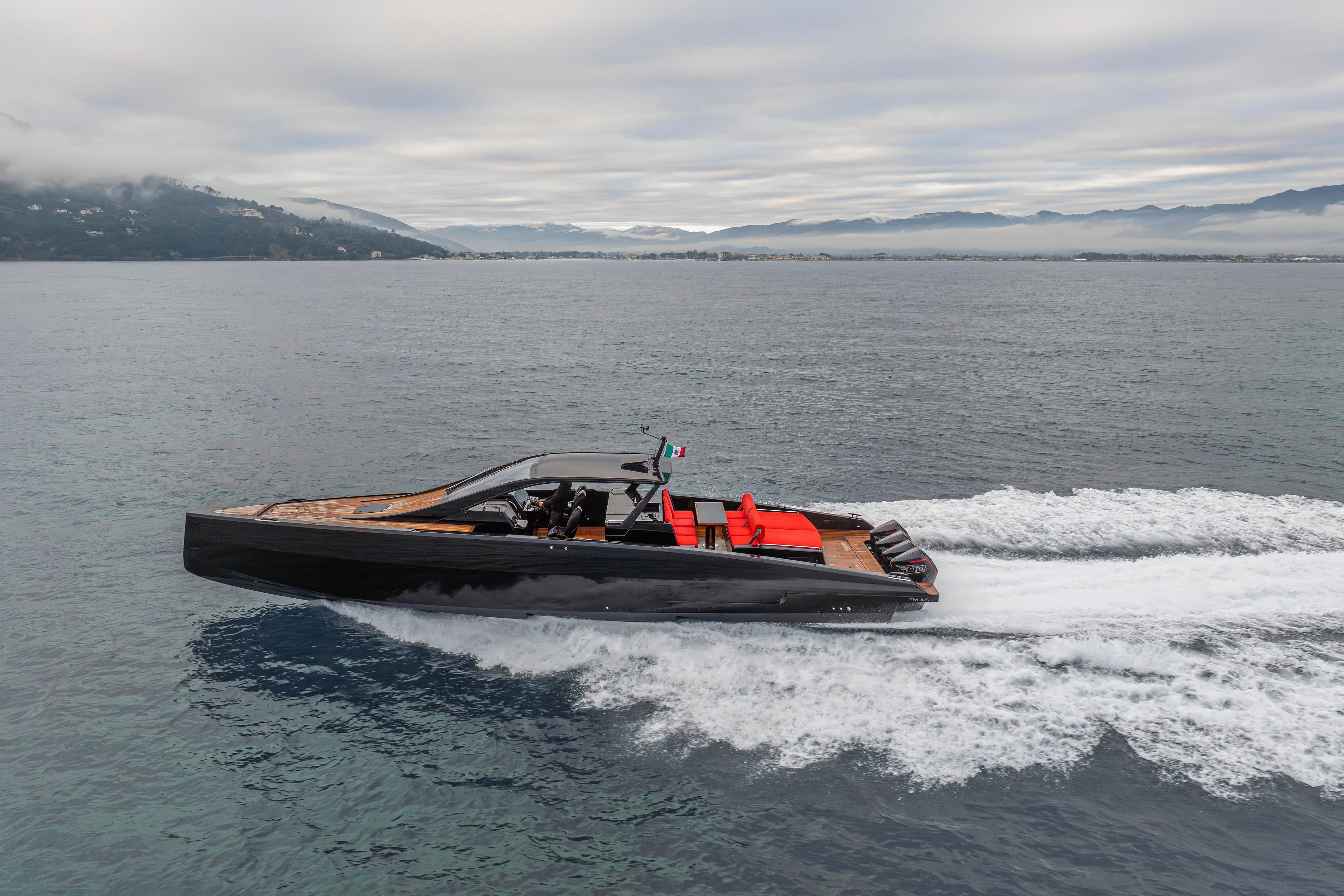 2025 Mylius M47P yacht cruising on open water with scenic mountain backdrop.
