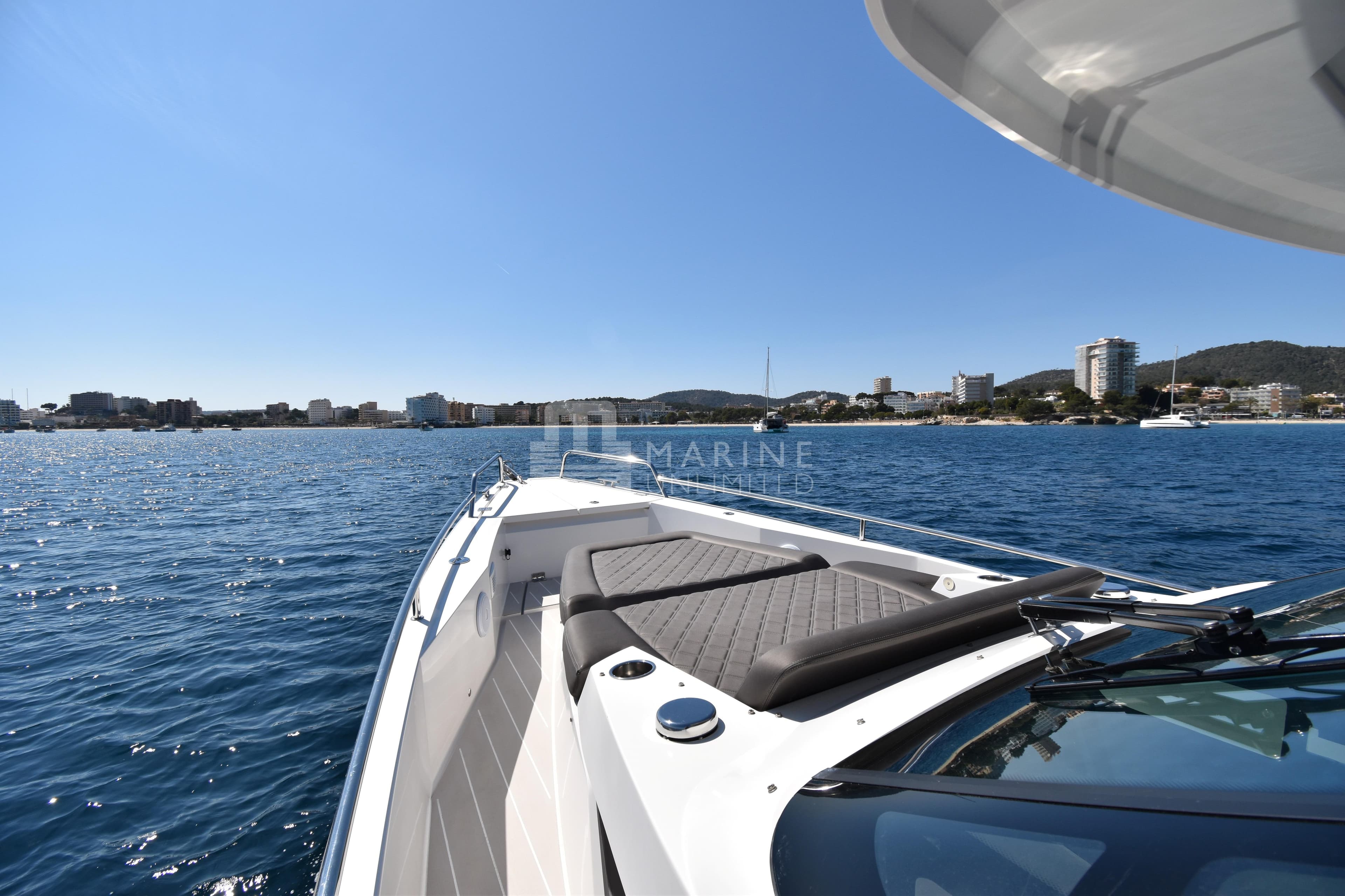 2016 Axopar 37 Sun-Top boat cruising near coastal city skyline.