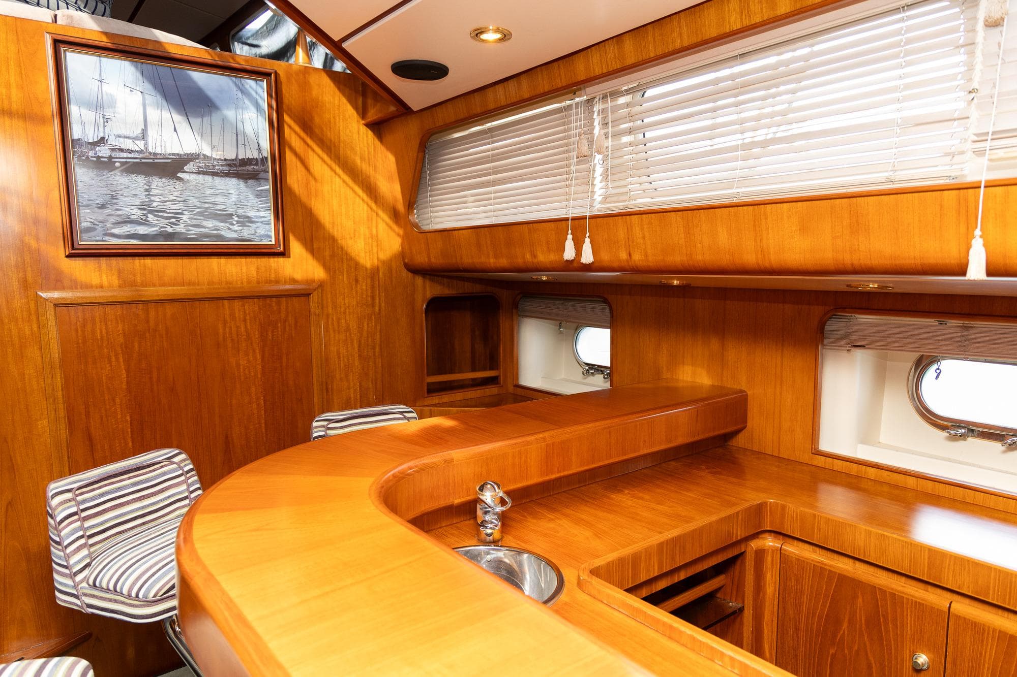 Luxurious wooden interior of a 1996 Jongert 30M yacht with seating and windows.