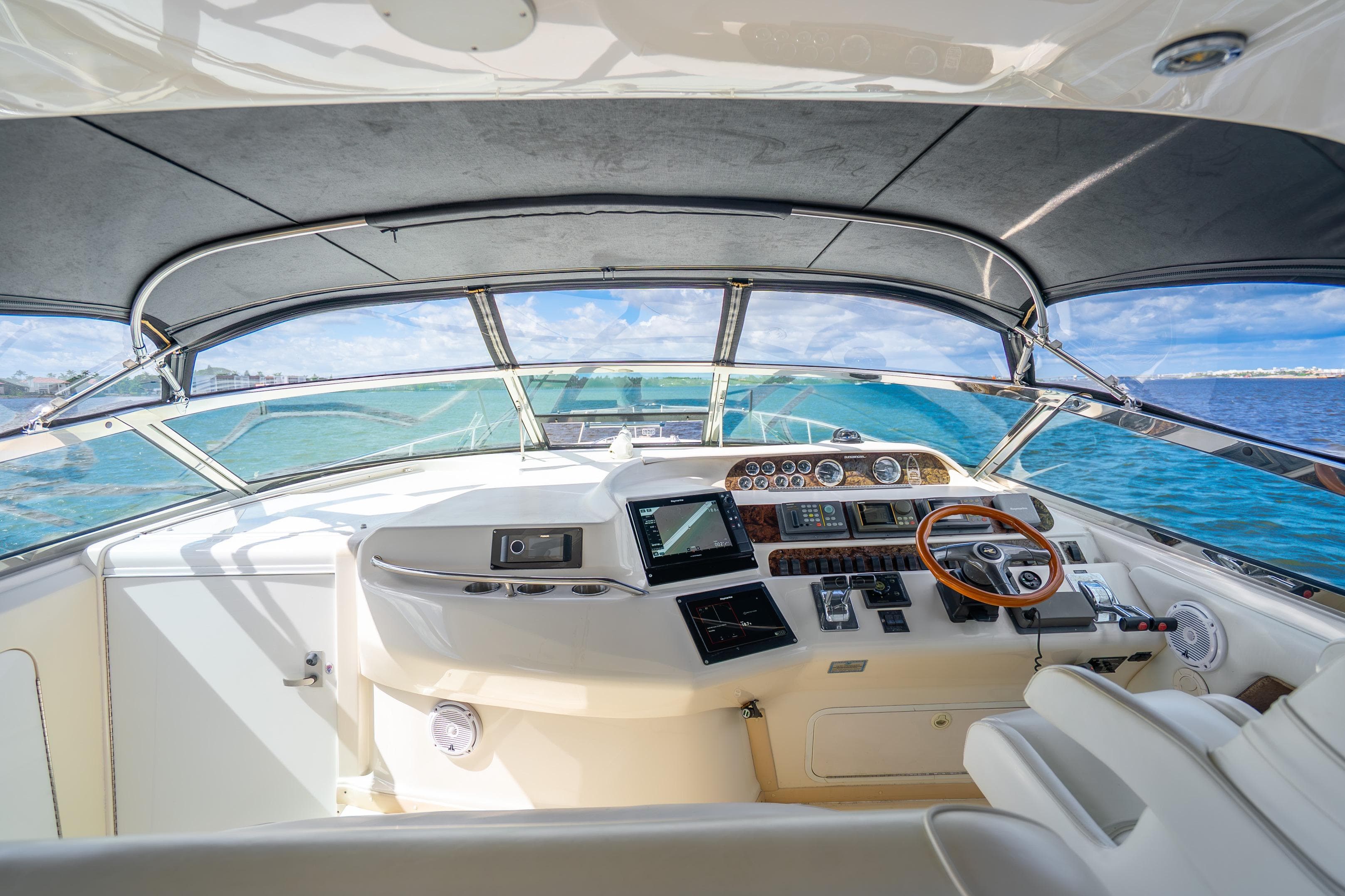1998 Sea Ray 450 Sundancer helm with ocean view, featuring modern navigation equipment.