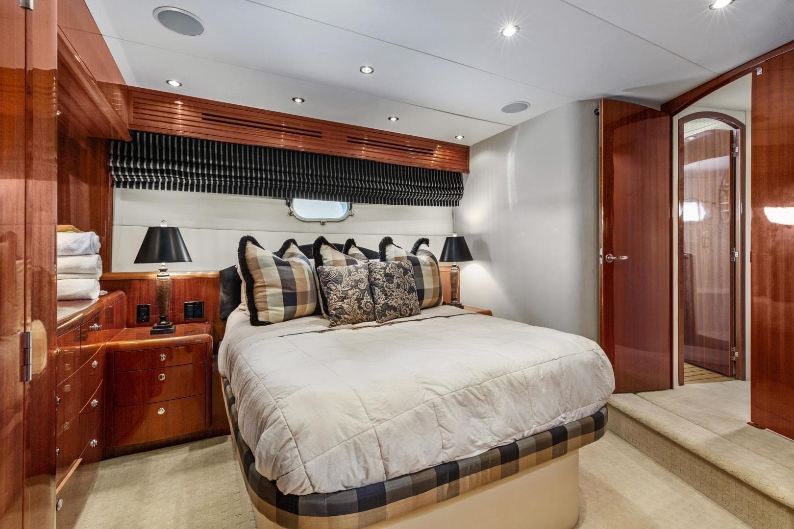 Luxurious bedroom in 2002 Hatteras 63 Raised Pilothouse Motor Yacht with elegant wood finishes.