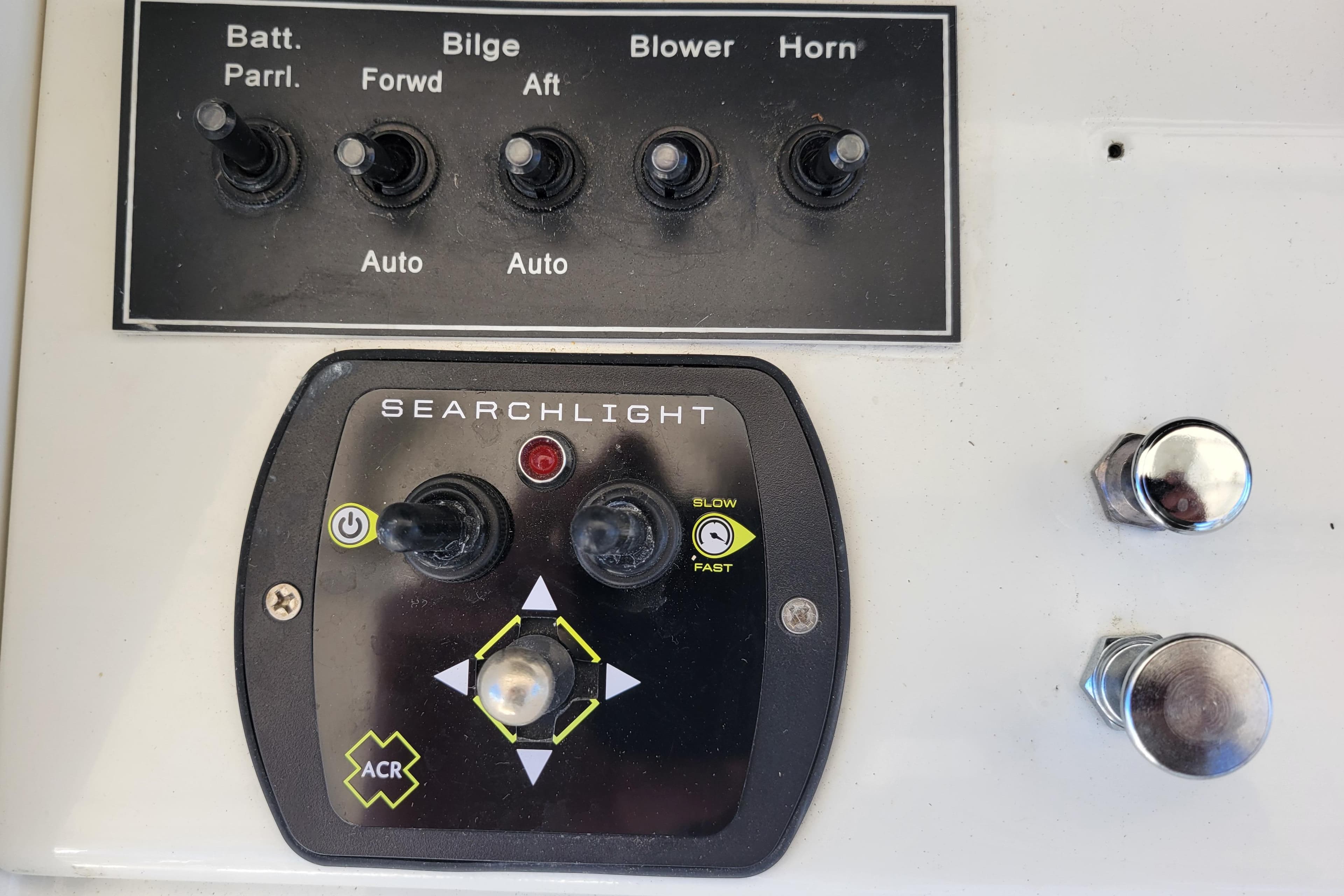 Control panel of a 1979 Bertram 38 Convertible boat with searchlight and switches.
