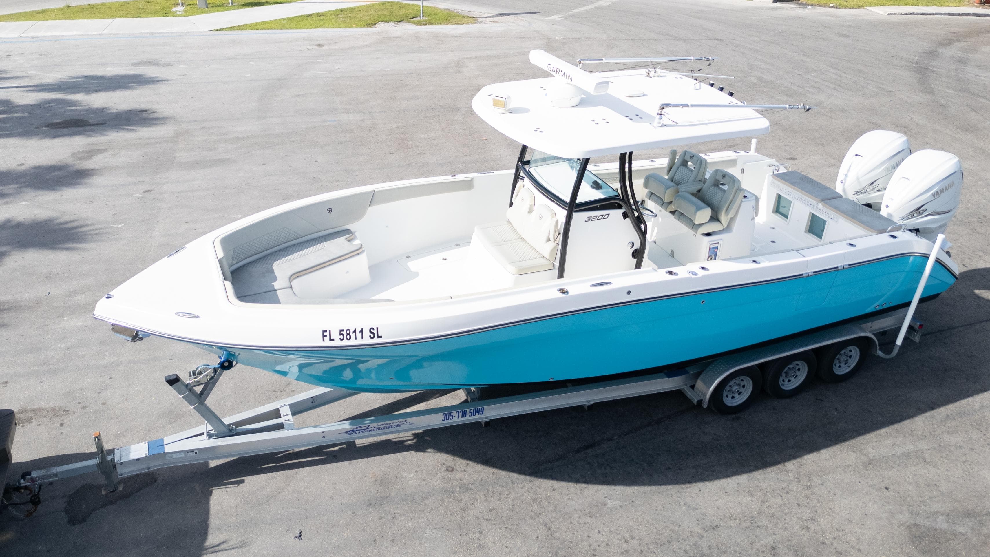 2019 Century 3200 Center Console boat on trailer, featuring a sleek blue and white design.